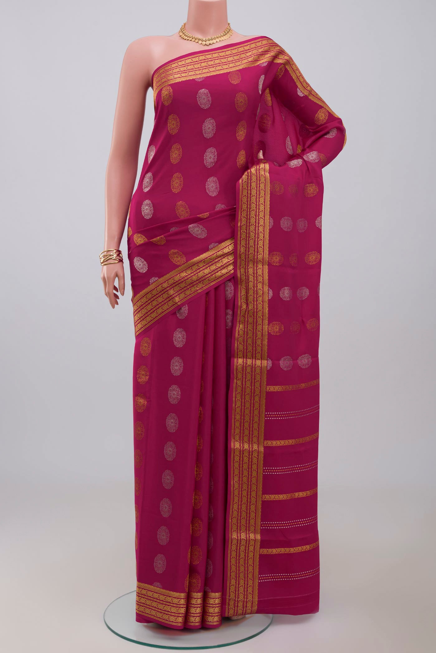Pink Crepe Saree with Zari Butta on the body and Zari Border.  displayed on a mannequin