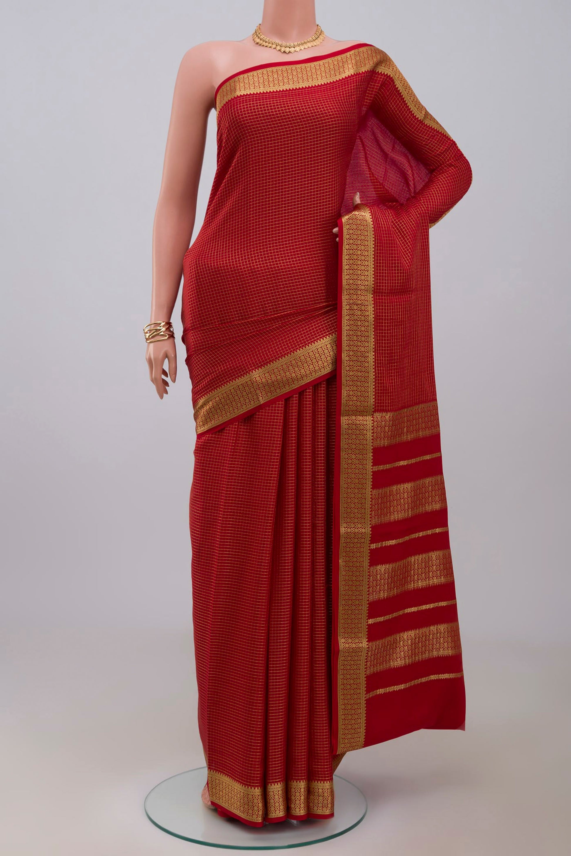 Red Crepe Saree with Checked design on the body and Zari Border.  displayed on a mannequin