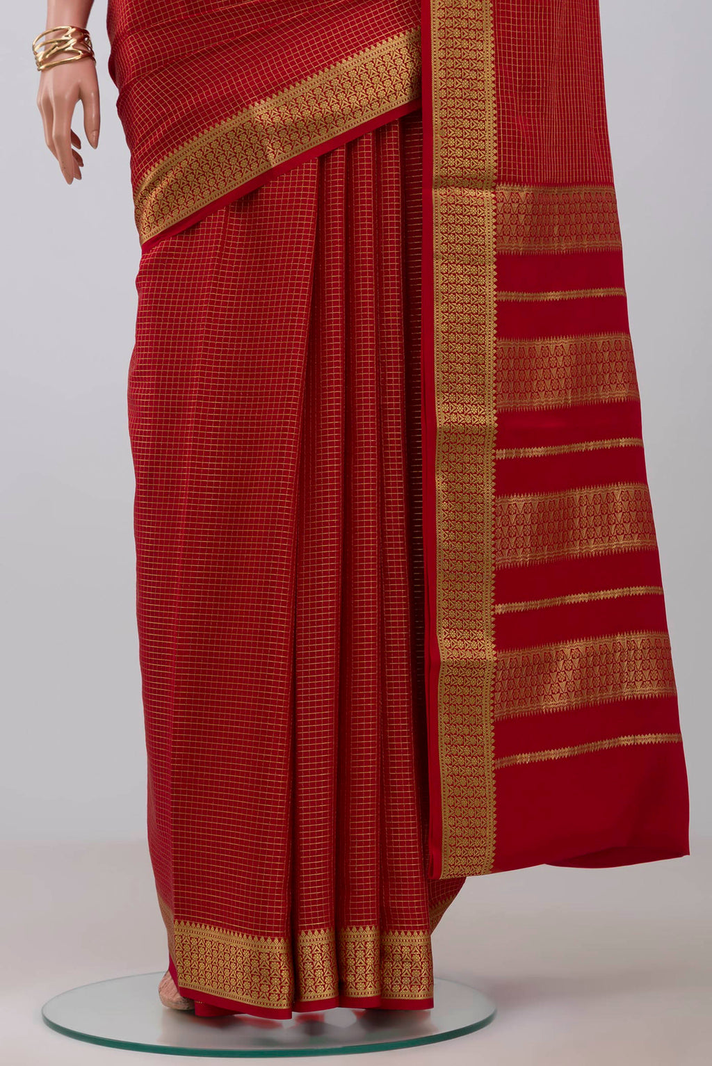 Pleats and pallu of Red Crepe Saree with Checked design on the body and Zari Border. 