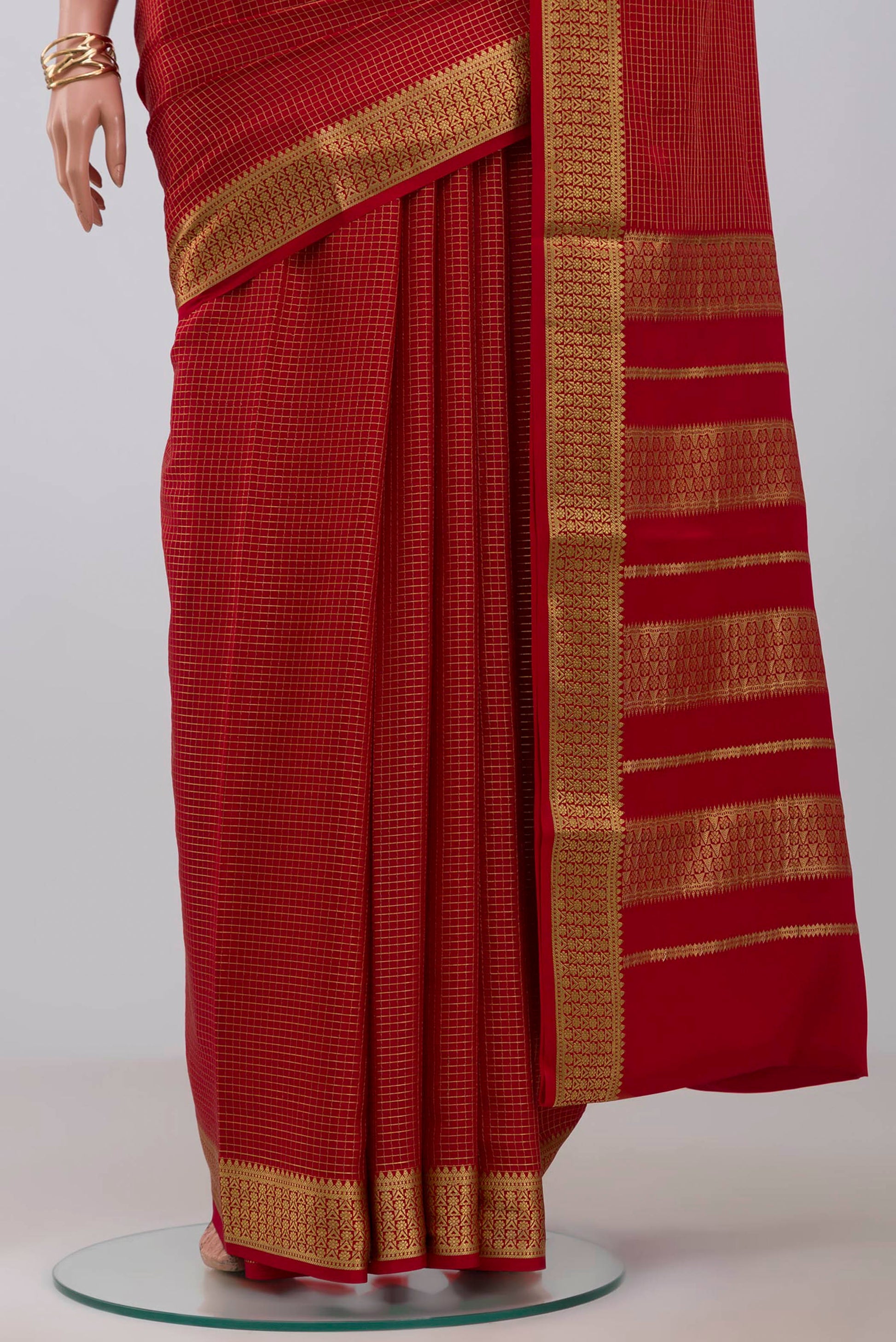 Pleats and pallu of Red Crepe Saree with Checked design on the body and Zari Border. 