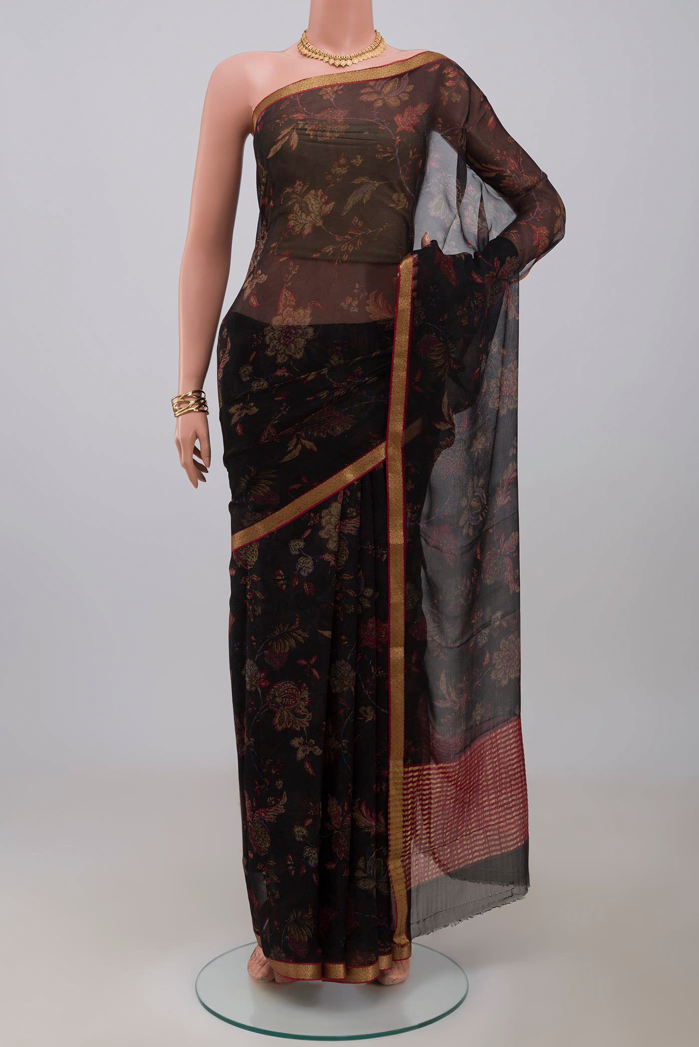 Black Chiffon Saree with Printed design on the body and Zari Border.  displayed on a mannequin