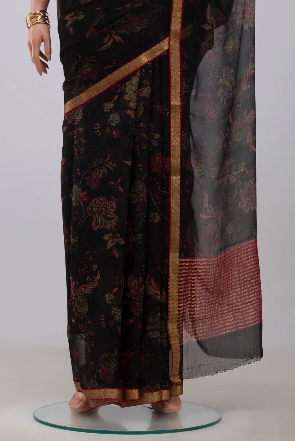 Pleats and pallu of Black Chiffon Saree with Printed design on the body and Zari Border. 