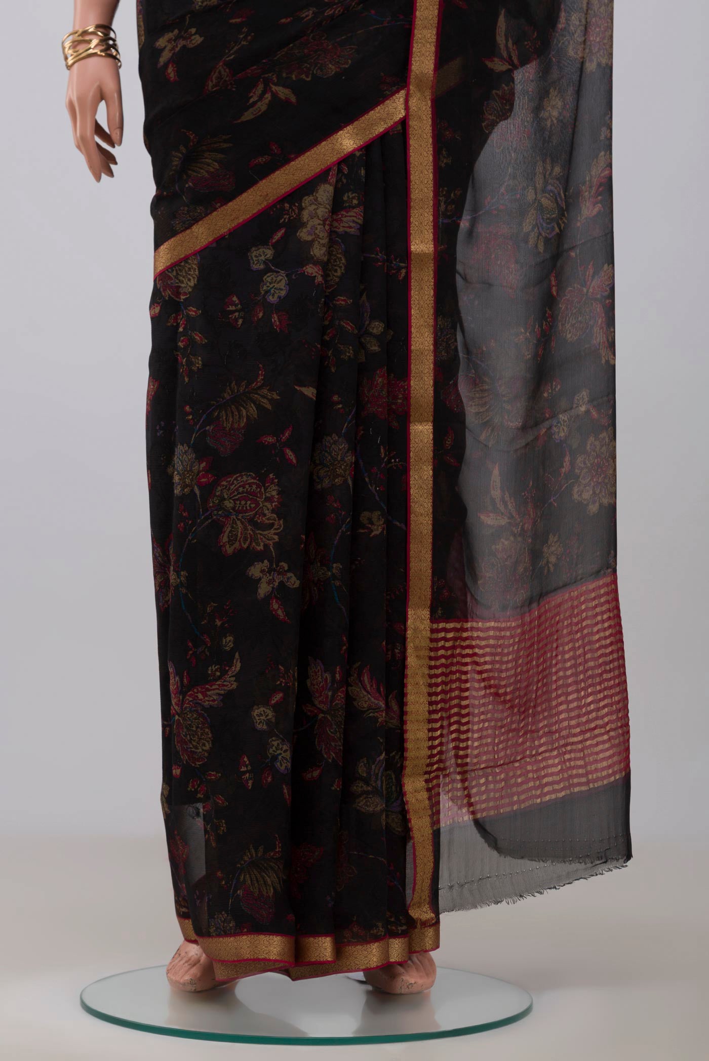 Pleats and pallu of Black Chiffon Saree with Printed design on the body and Zari Border. 