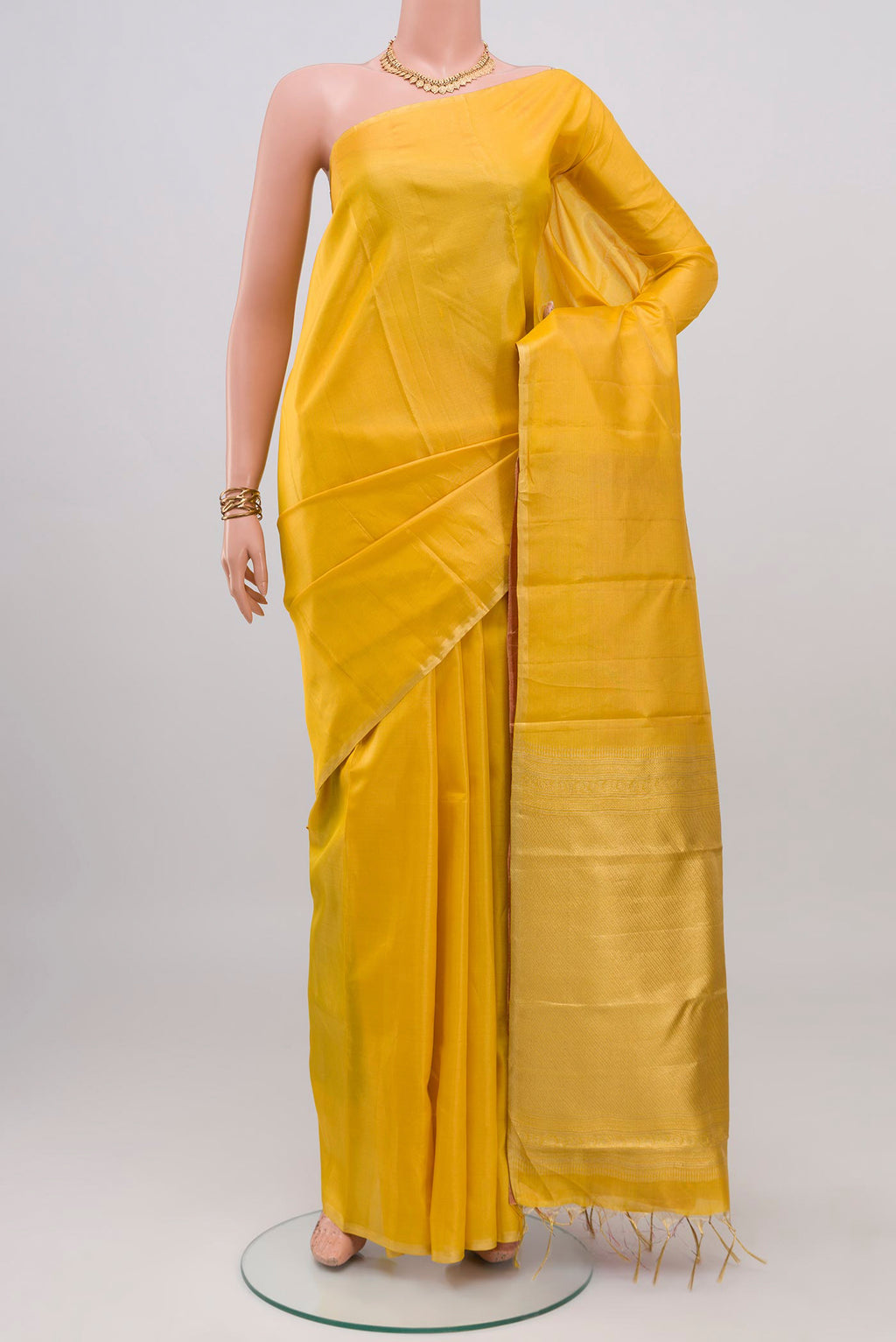 Yellow Soft Silk Saree with Plain Body and Zari Border.  displayed on a mannequin