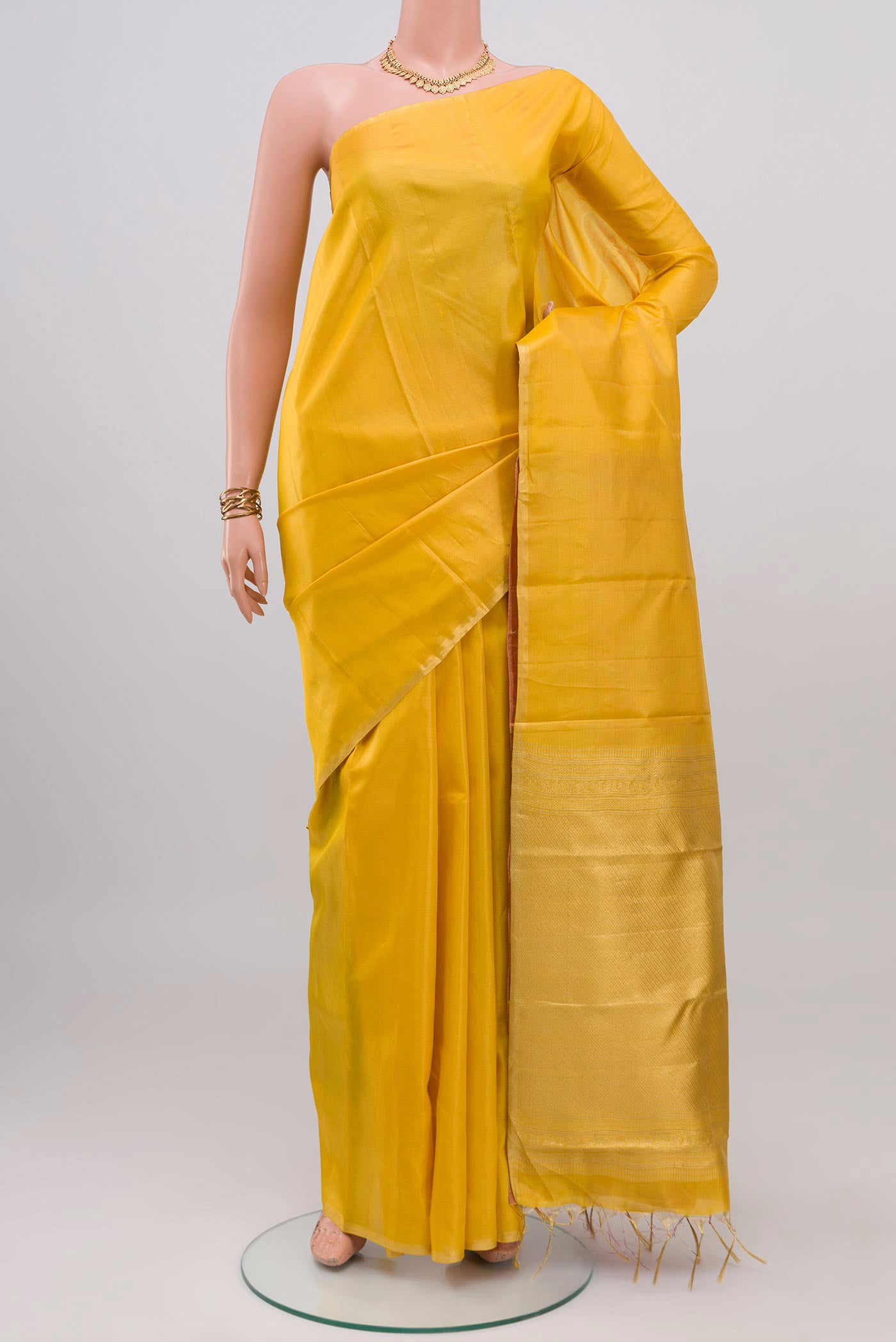 Yellow Soft Silk Saree with Plain Body and Zari Border.  displayed on a mannequin