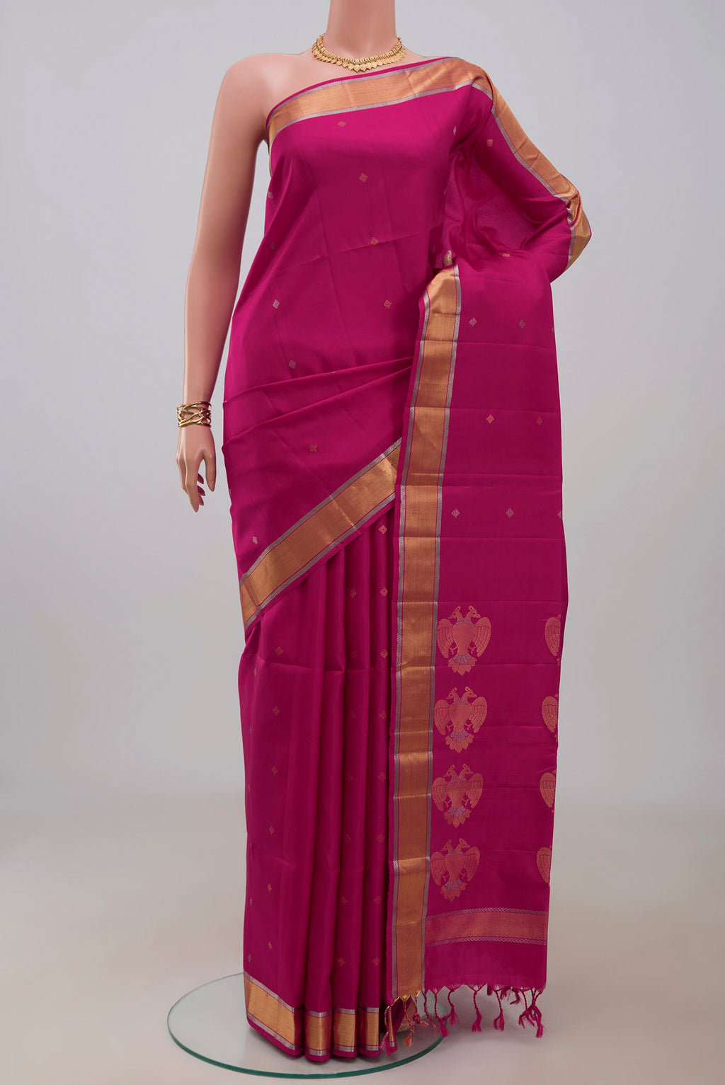 Rani Pink Soft Silk Saree with Zari Butta on the body and Zari Border.  displayed on a mannequin