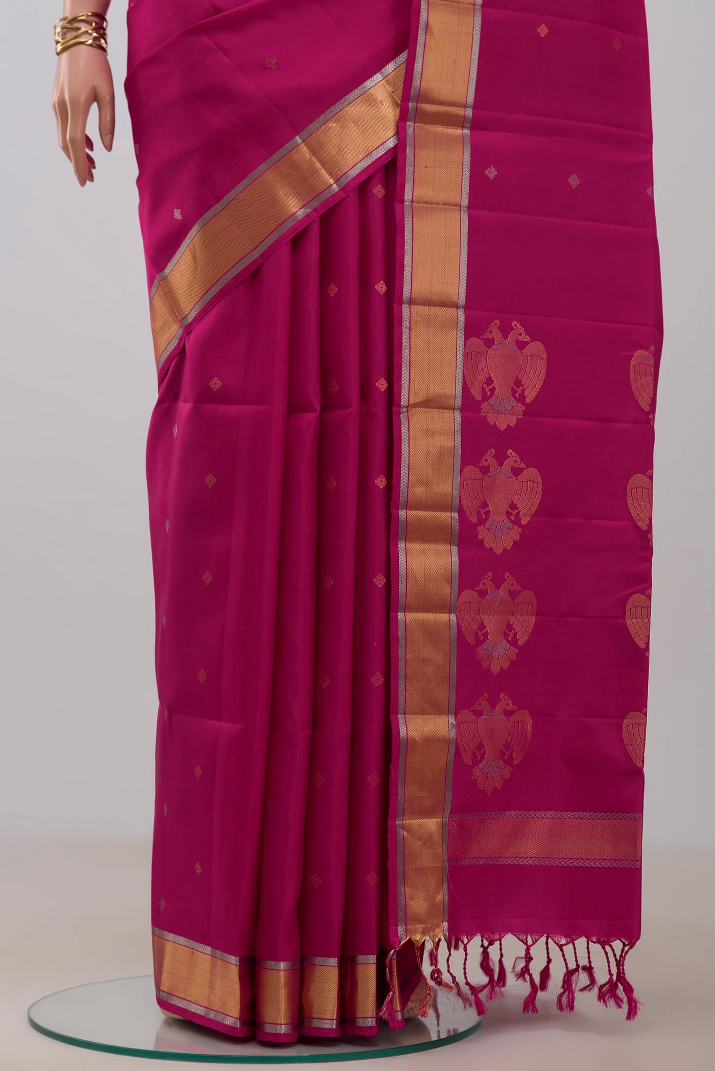 Pleats and pallu of Rani Pink Soft Silk Saree with Zari Butta on the body and Zari Border. 
