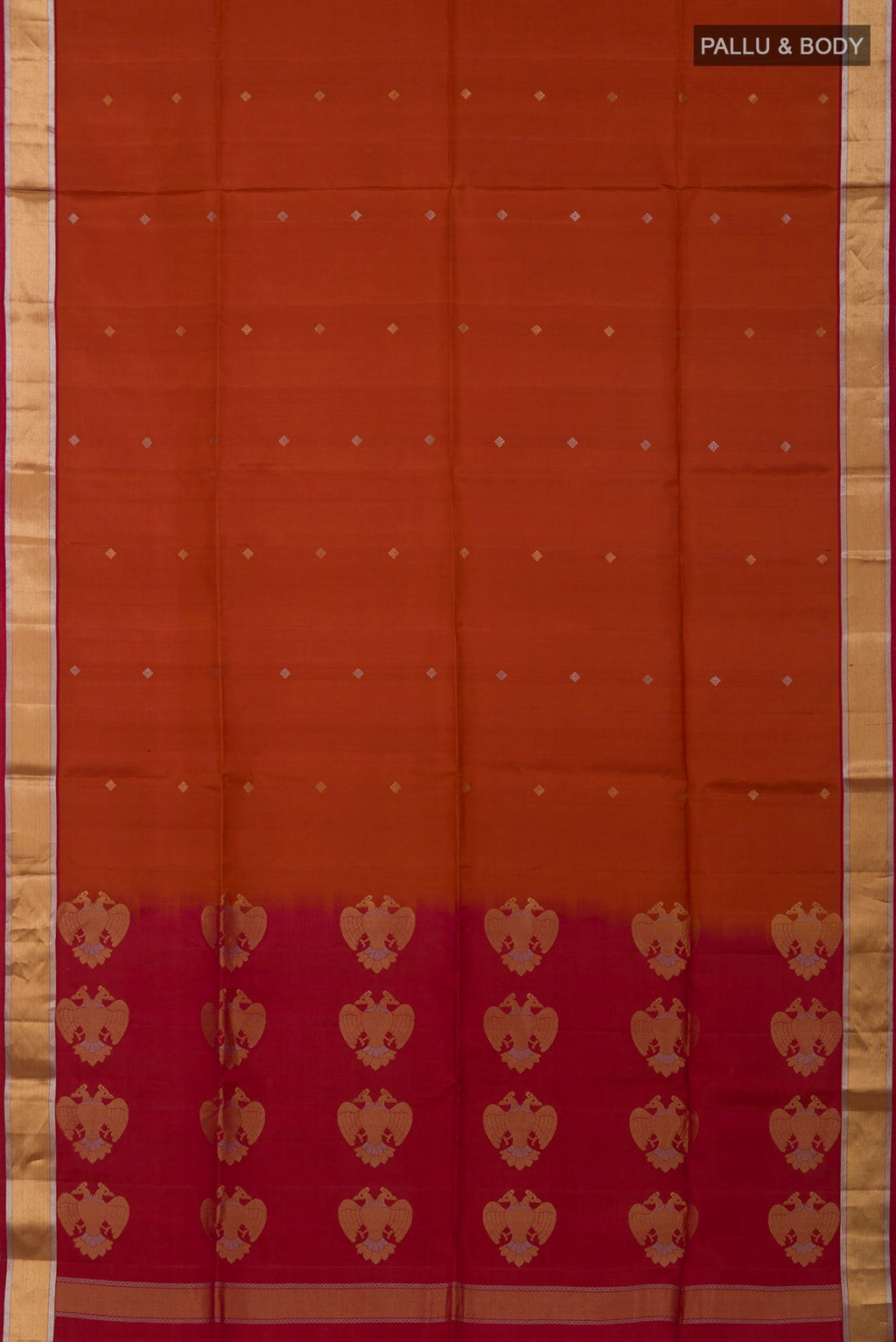 Flat view of Rust Soft Silk Saree with Zari Butta on the body and Zari Border. 