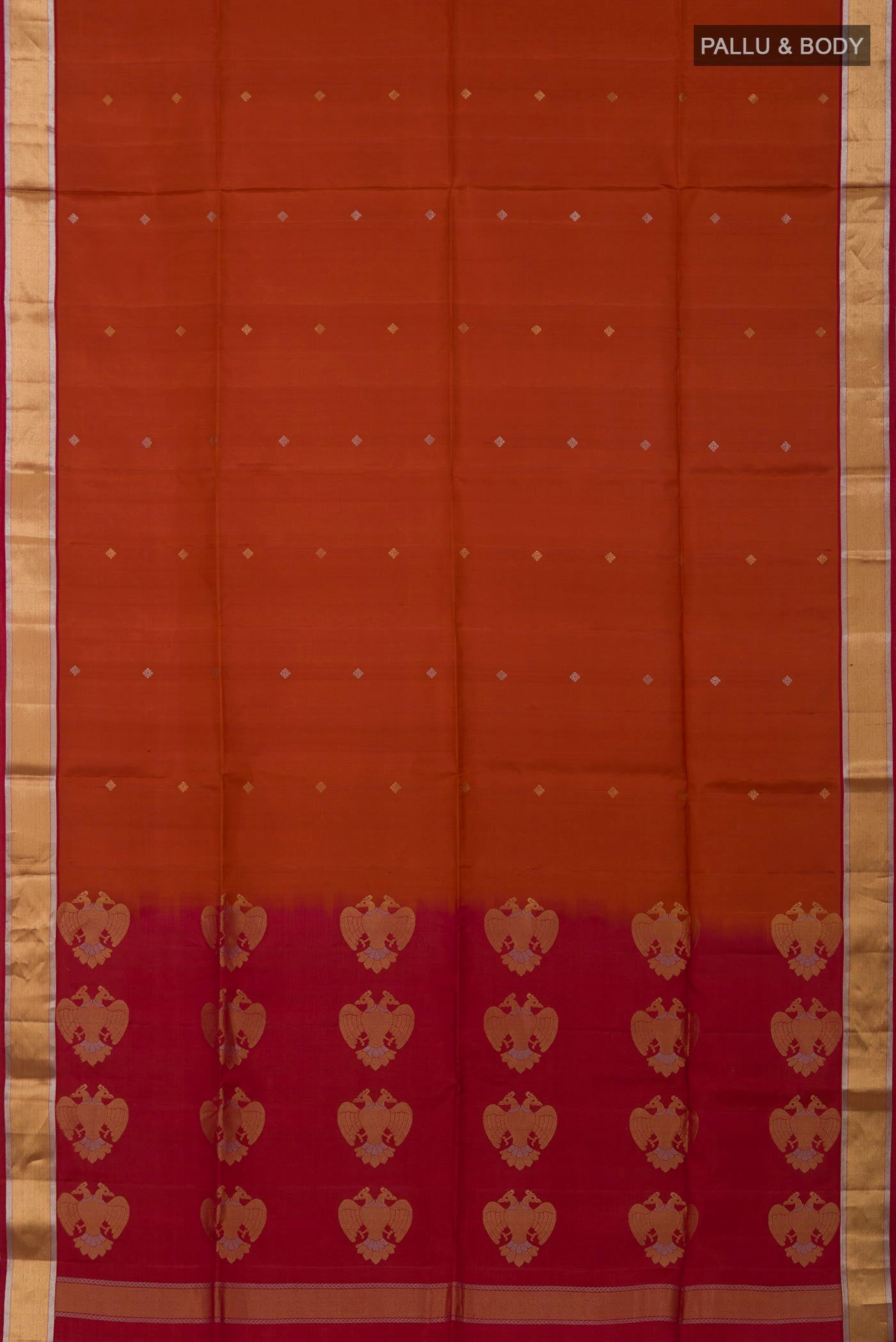 Flat view of Rust Soft Silk Saree with Zari Butta on the body and Zari Border. 