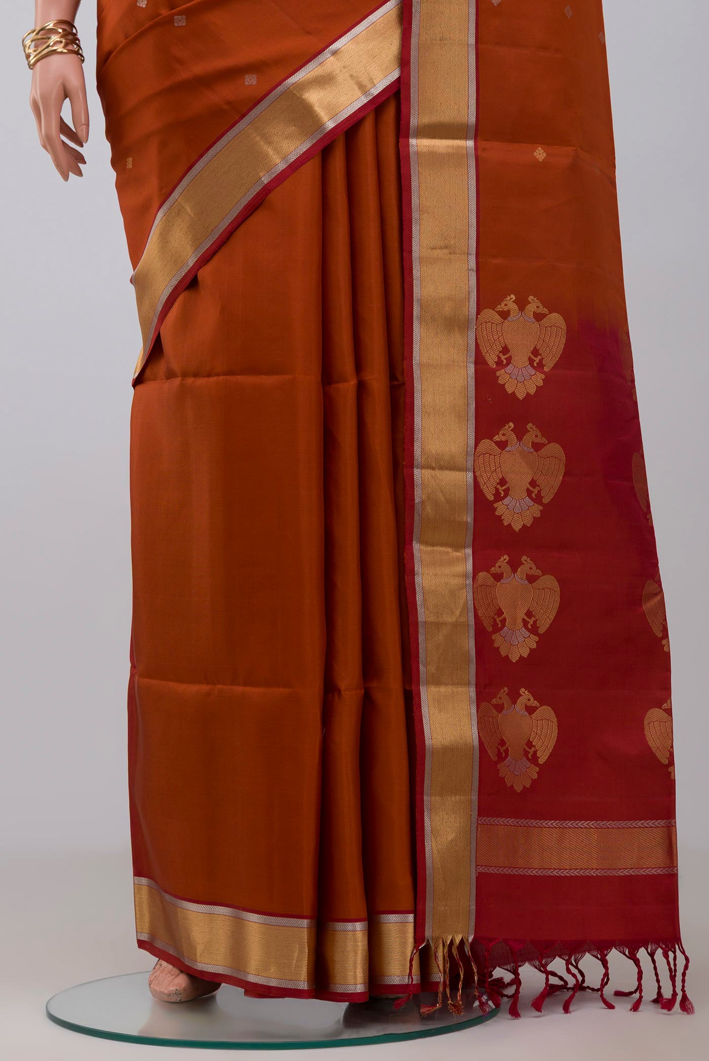Pleats and pallu of Rust Soft Silk Saree with Zari Butta on the body and Zari Border. 