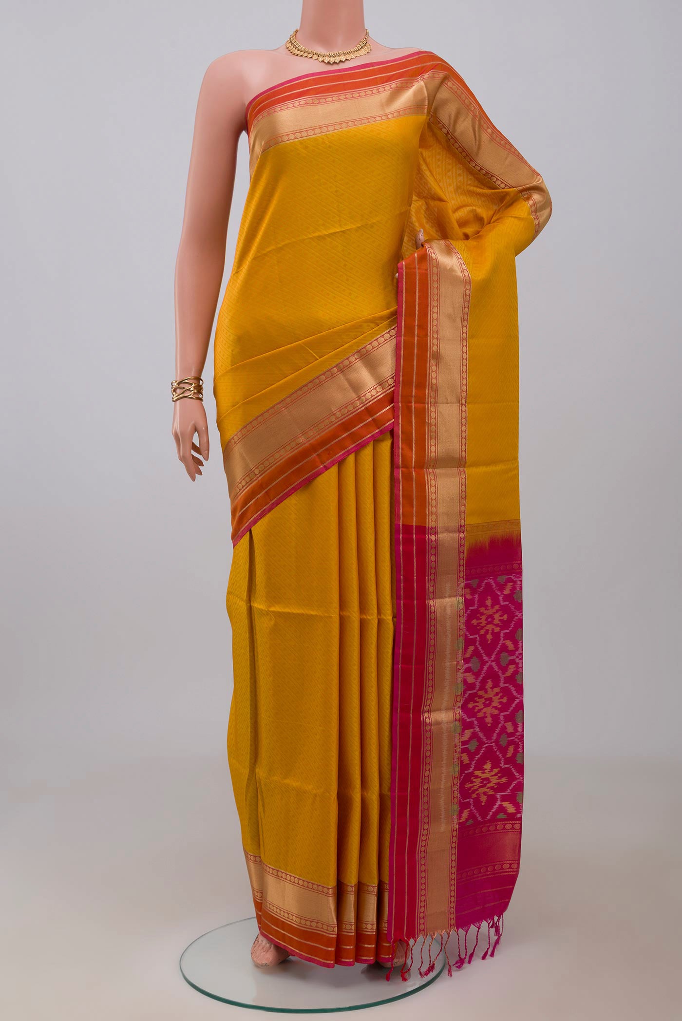 Mustard Soft Silk Saree with Jacquard design on the body and Zari Border.  displayed on a mannequin