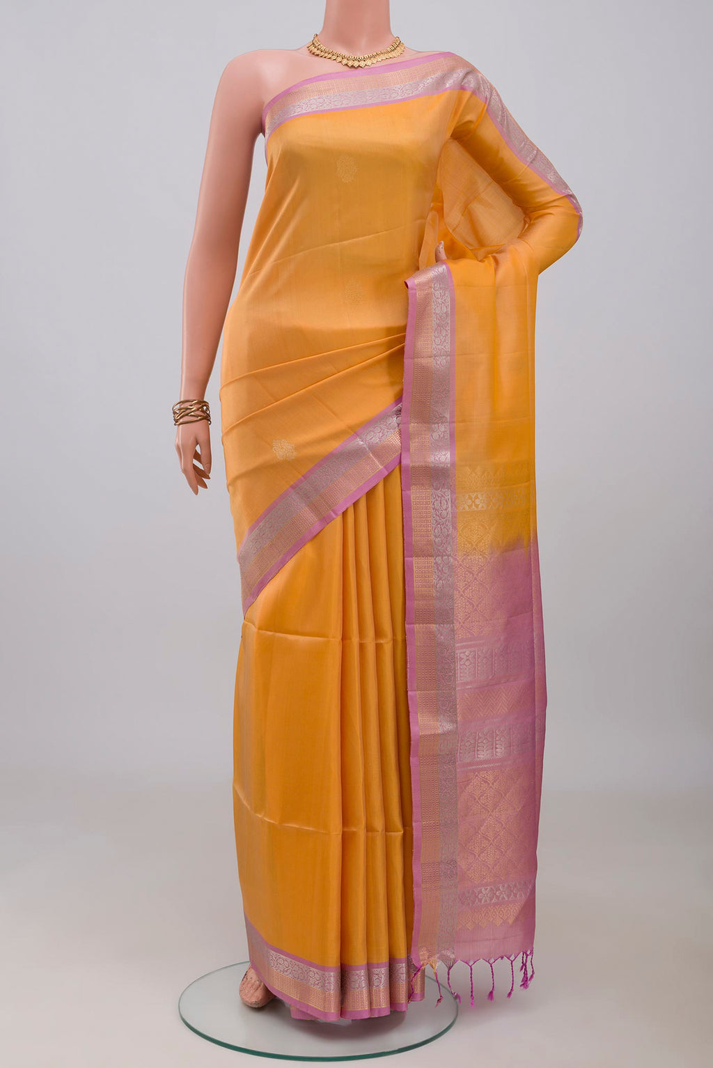 Yellow Soft Silk Saree with Zari Butta on the body and Zari Border.  displayed on a mannequin