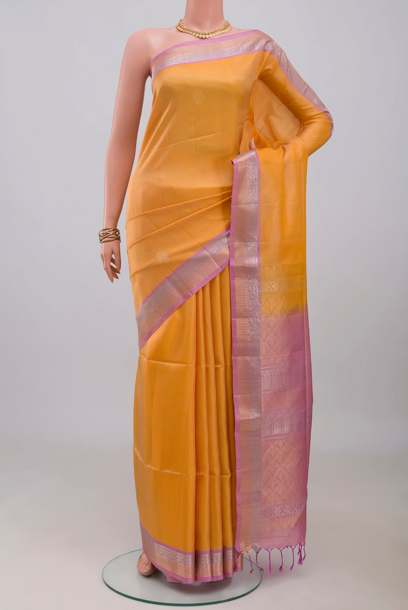 Yellow Soft Silk Saree with Zari Butta on the body and Zari Border.  displayed on a mannequin