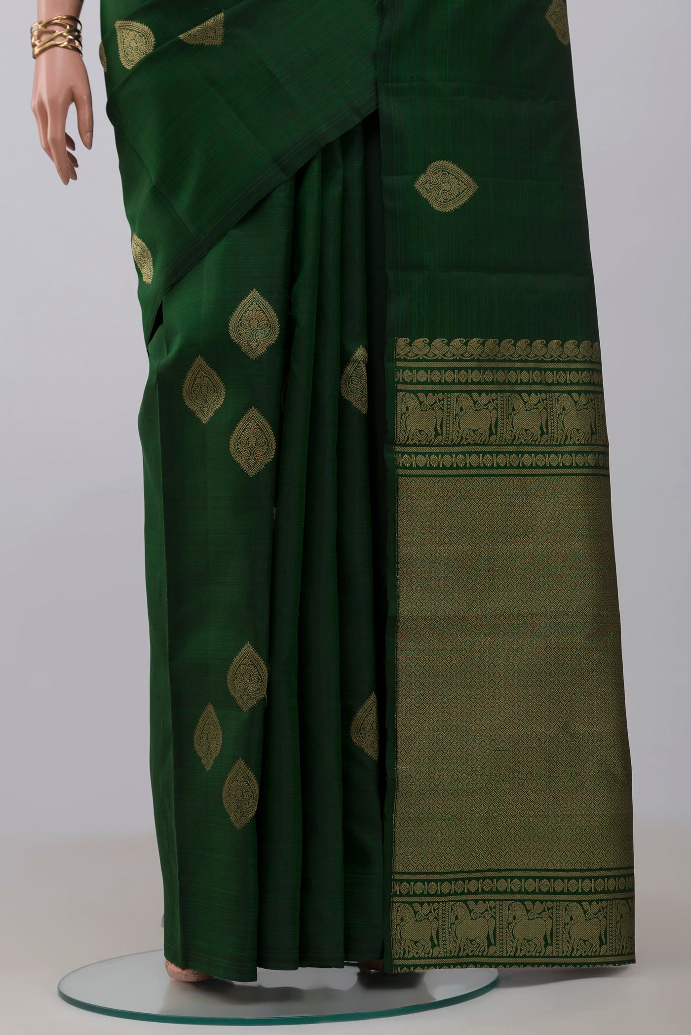 Pleats and pallu of Bottle Green Kanchipuram Silk Saree with Zari Butta on the body and Without Border. 