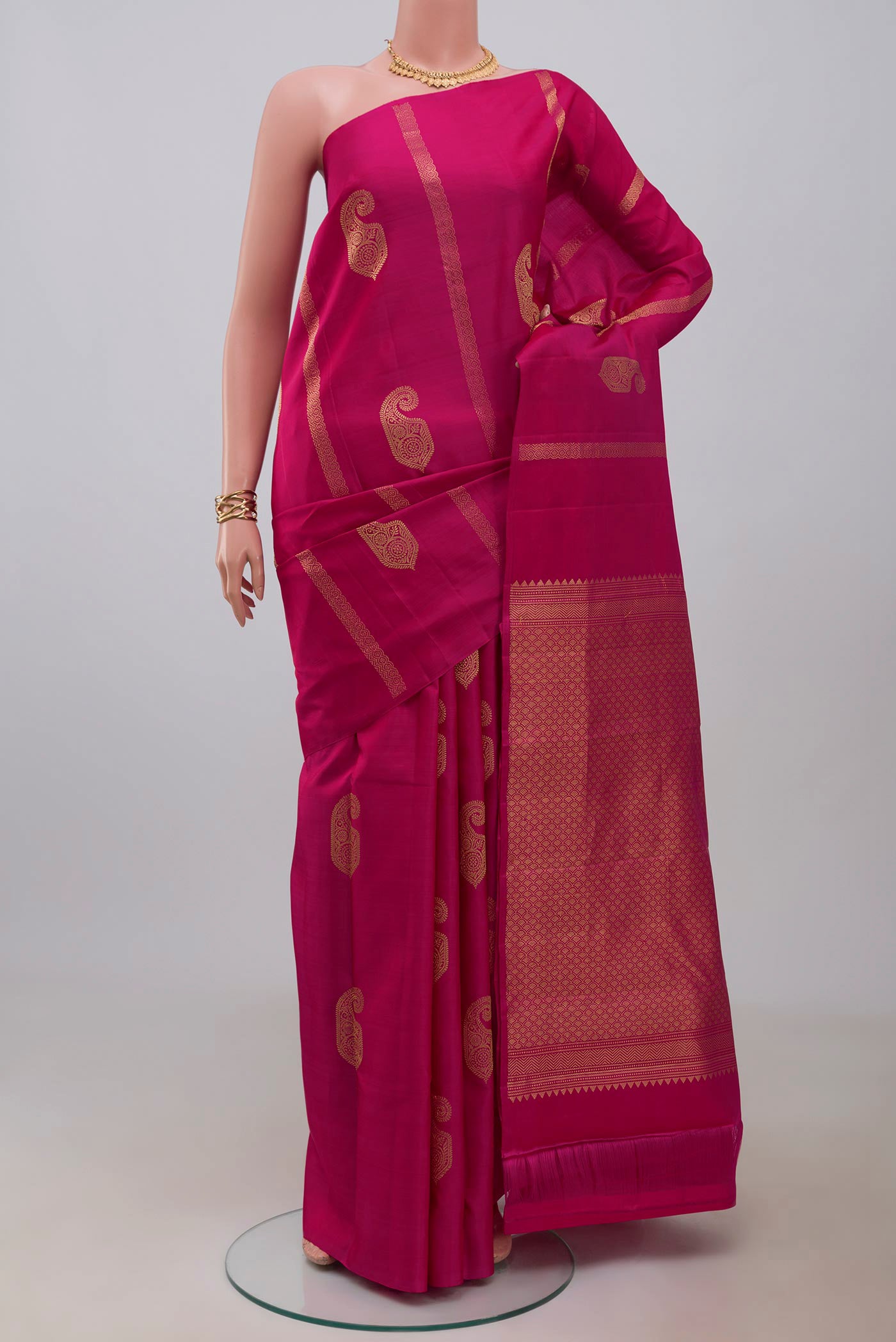 Rani Pink Kanchipuram Silk Saree with Zari Butta on the body and Without Border.  displayed on a mannequin