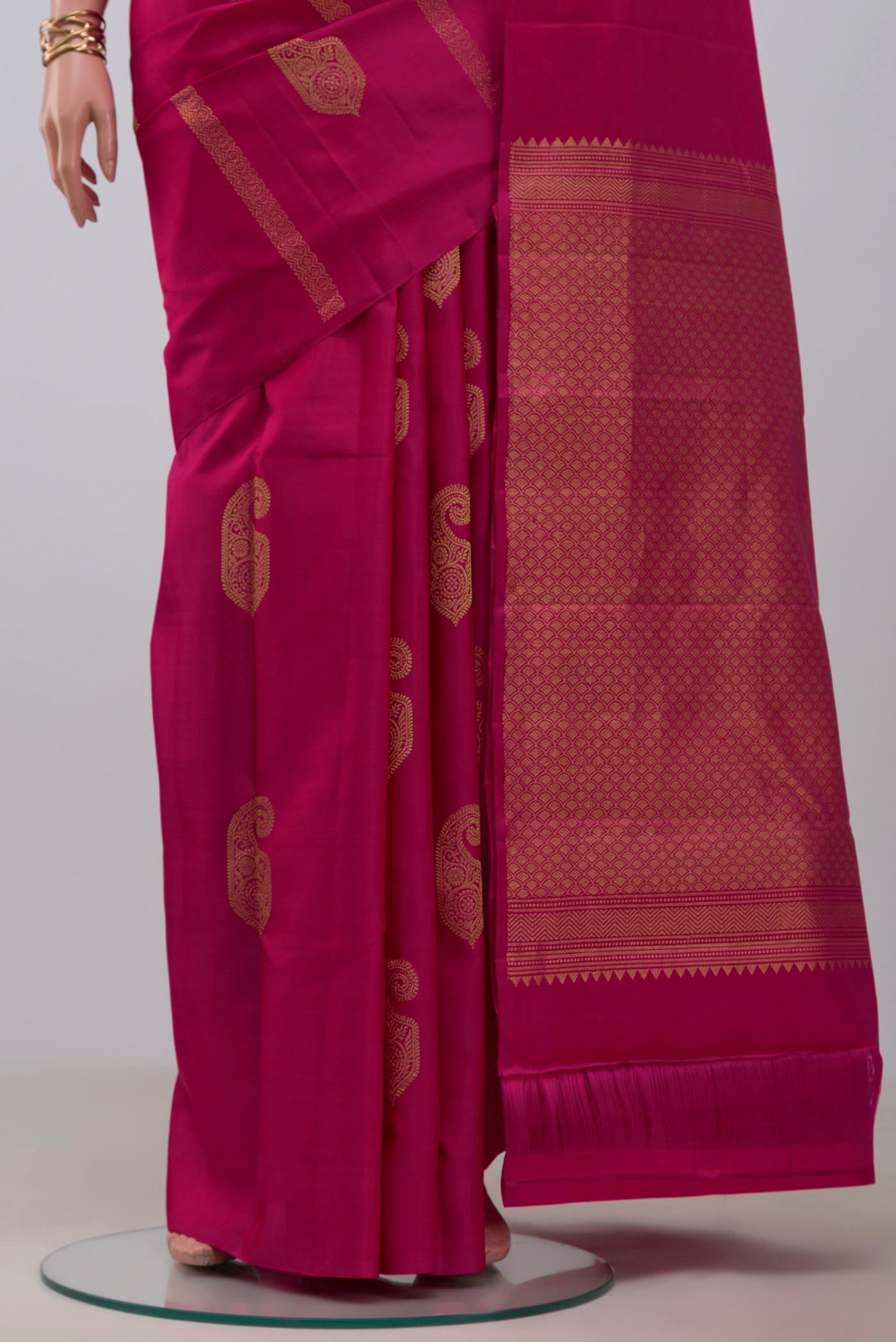 Pleats and pallu of Rani Pink Kanchipuram Silk Saree with Zari Butta on the body and Without Border. 