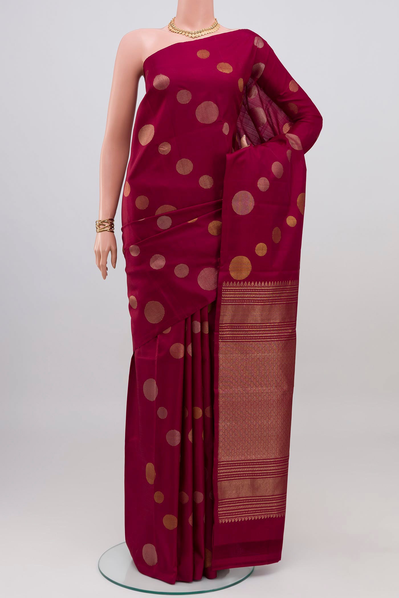 Maroon Kanjivaram Silk Saree with Zari Butta on the body and Without Border.  displayed on a mannequin