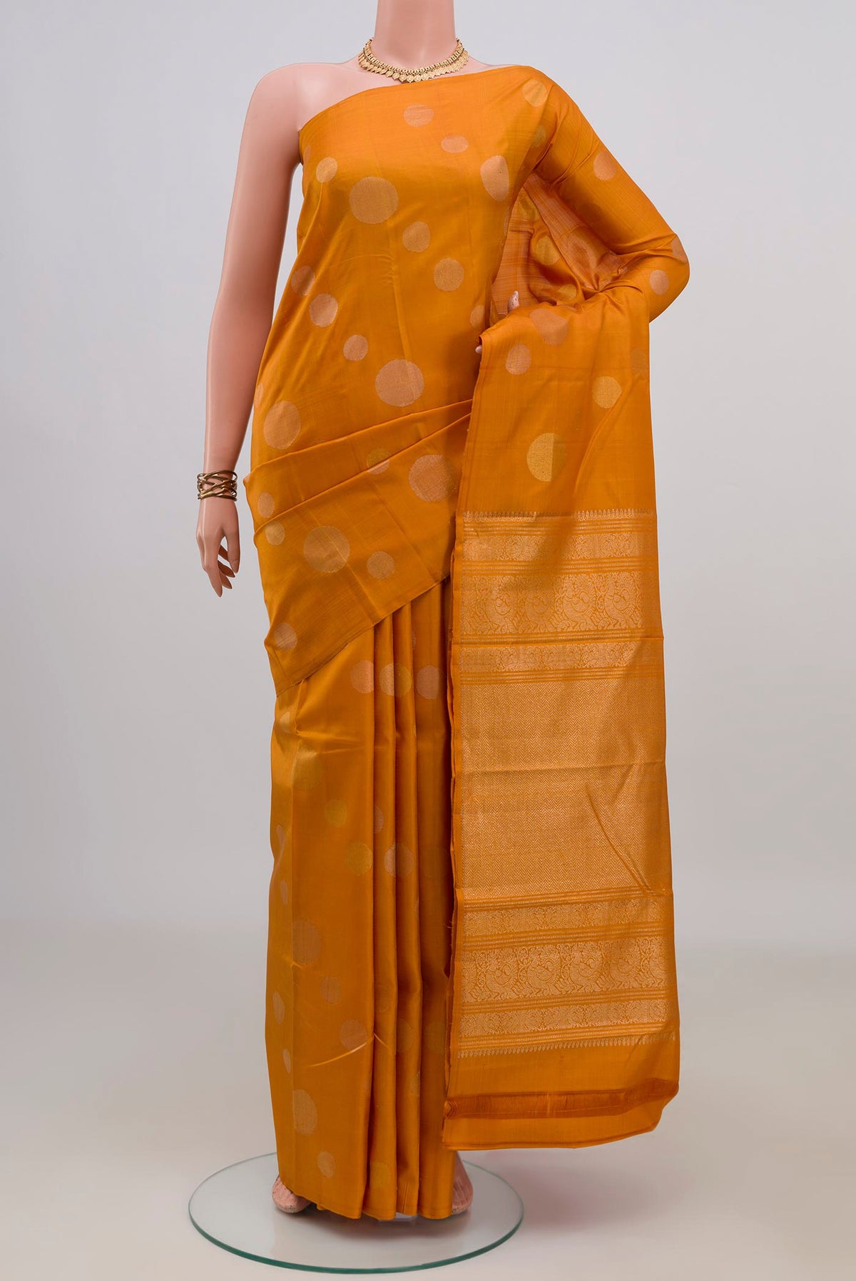 Pure Silk Mustard Kanjivaram Saree with Zari Butta on the body and Without Border.  displayed on a mannequin