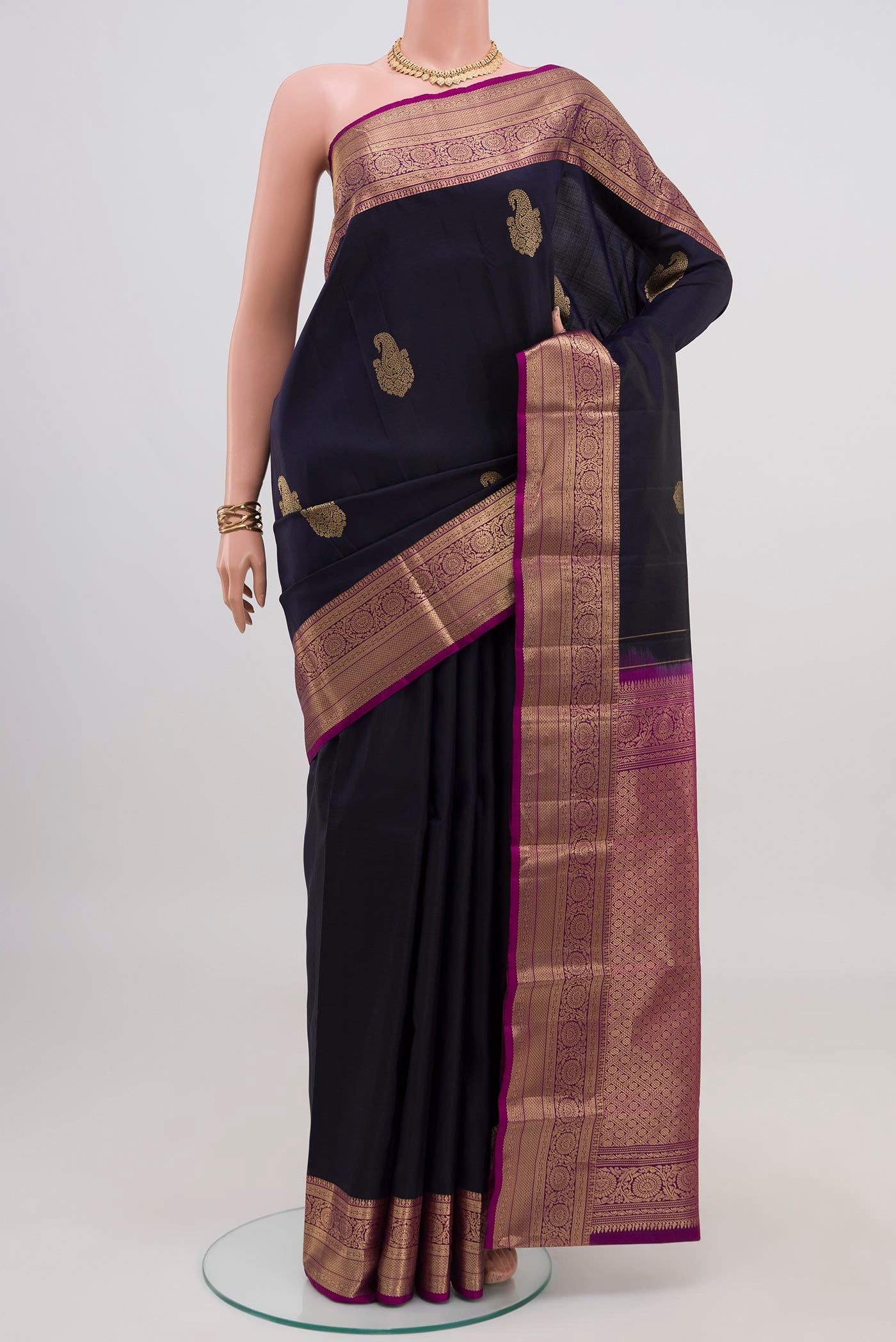 Navy Blue Kanchipuram Silk Saree with Zari Butta on the body and Zari Border.  displayed on a mannequin