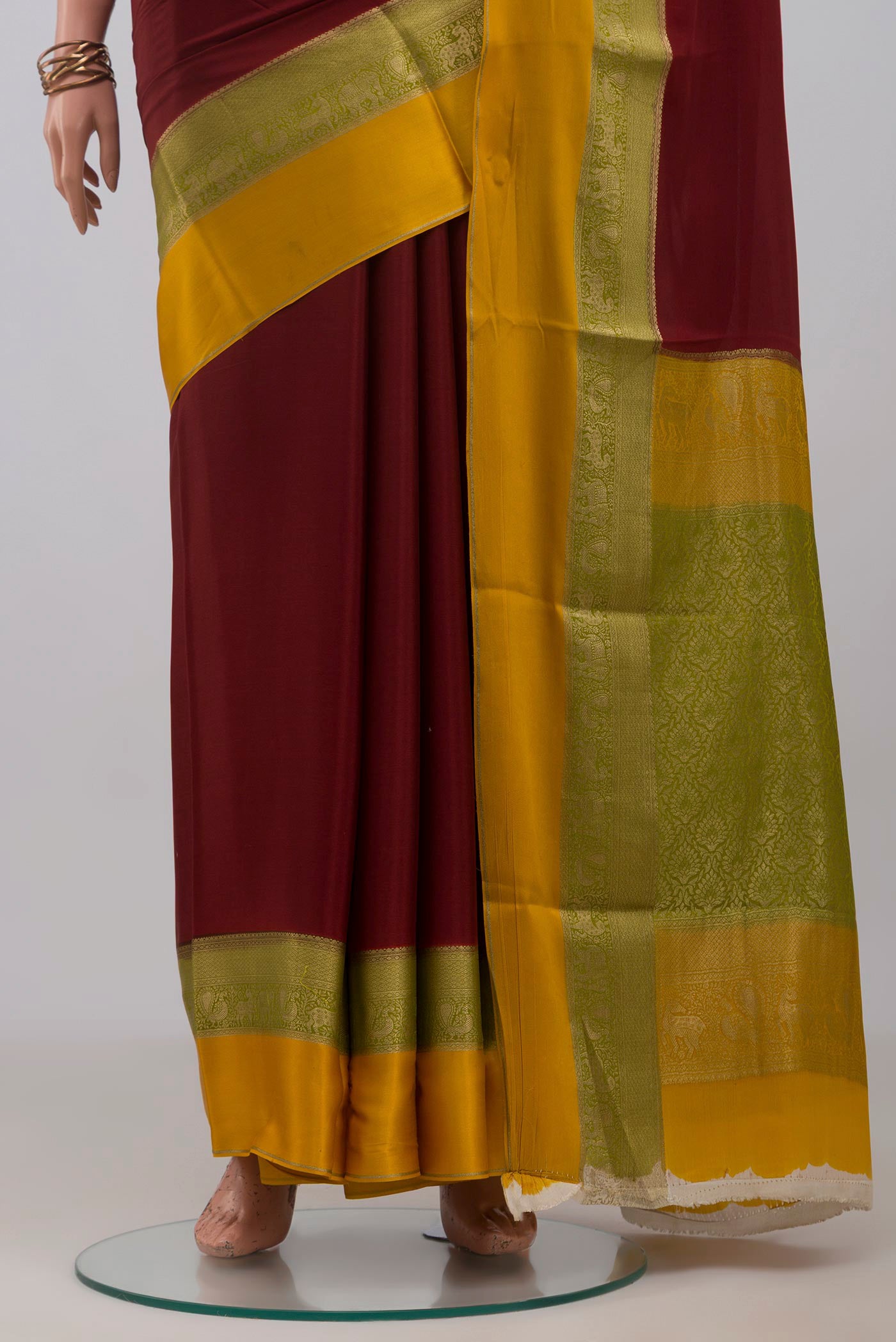 Pleats and pallu of Maroon Mysore Crepe Saree with Plain Body and Zari Border. 