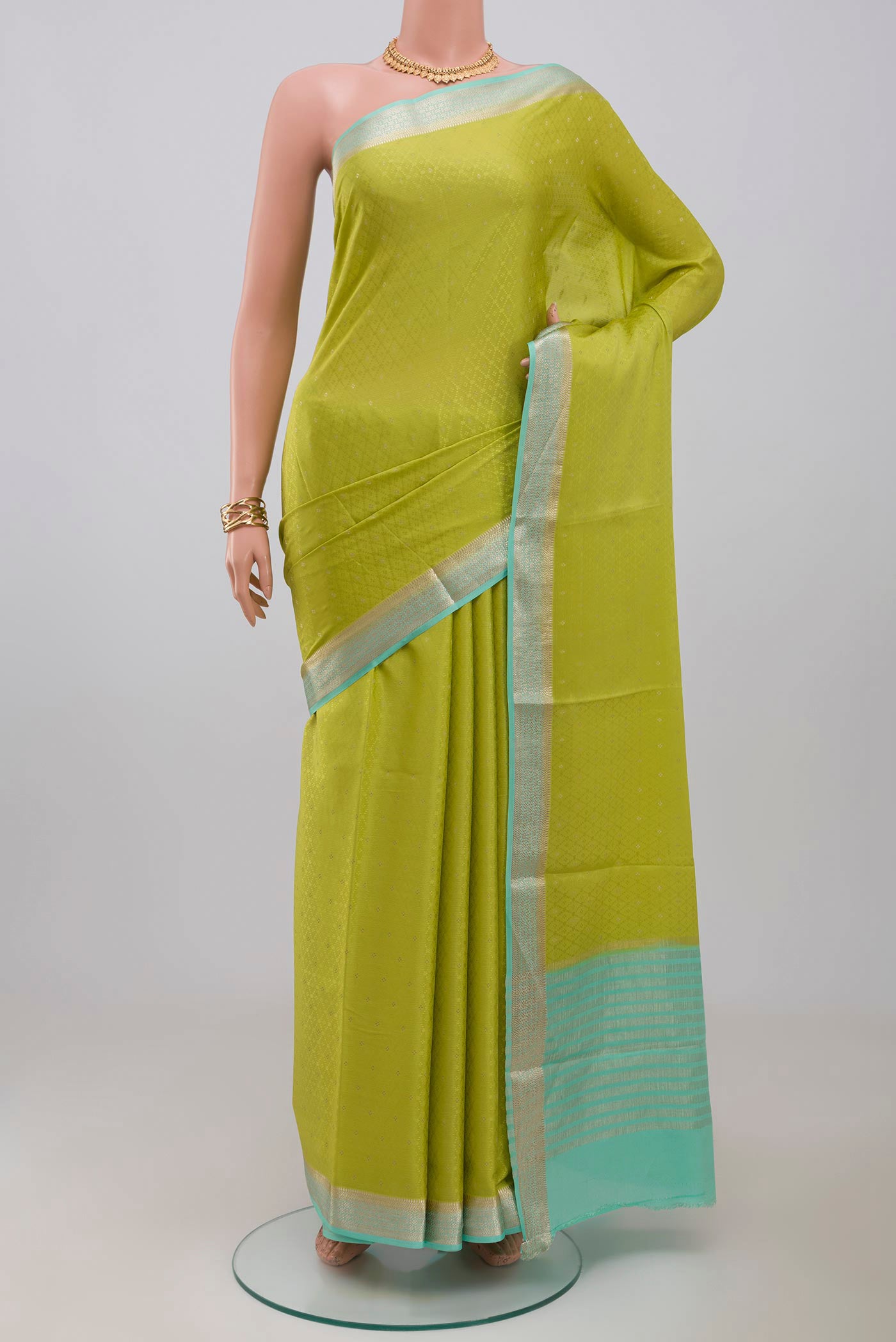 Parrot Green Crepe Saree with Fancy on the body and Zari Border.  displayed on a mannequin