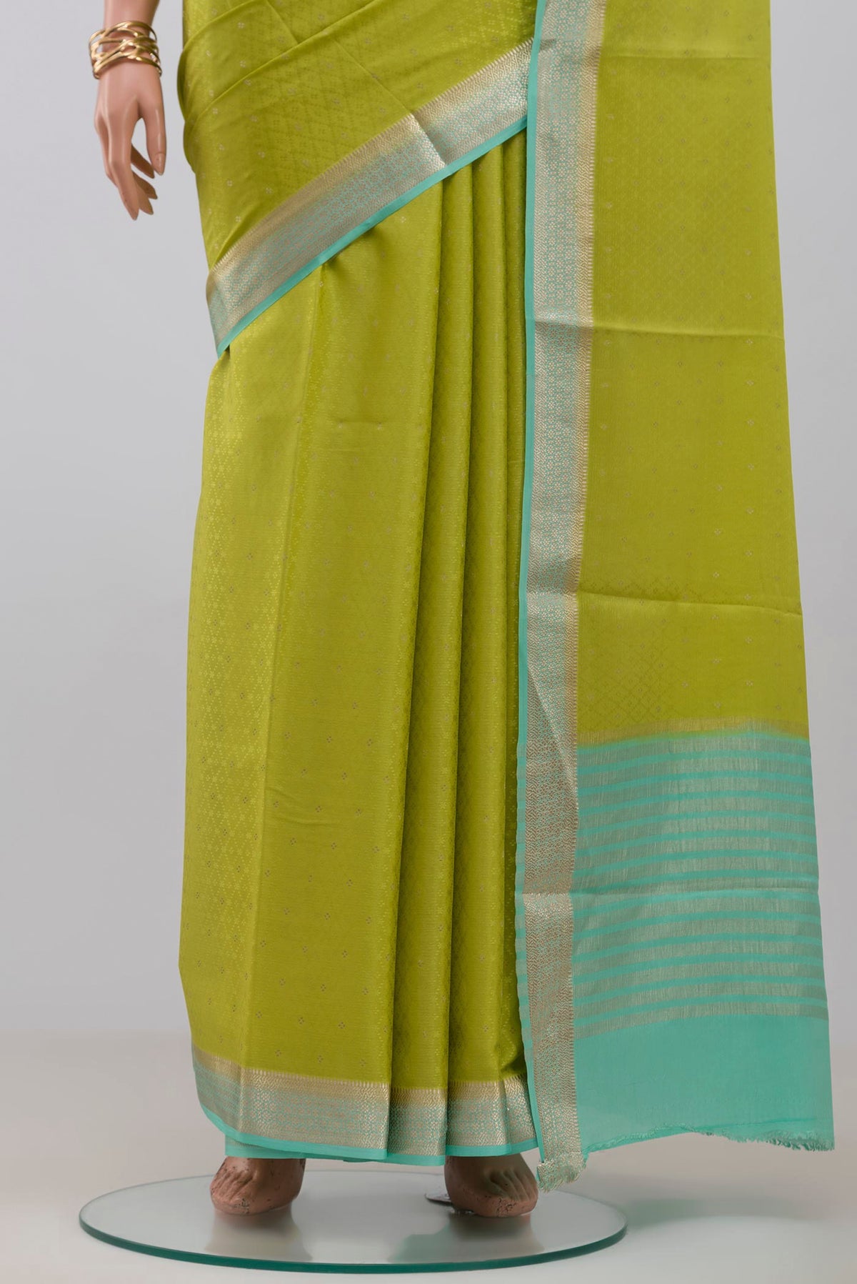 Pleats and pallu of Parrot Green Crepe Saree with Fancy on the body and Zari Border. 