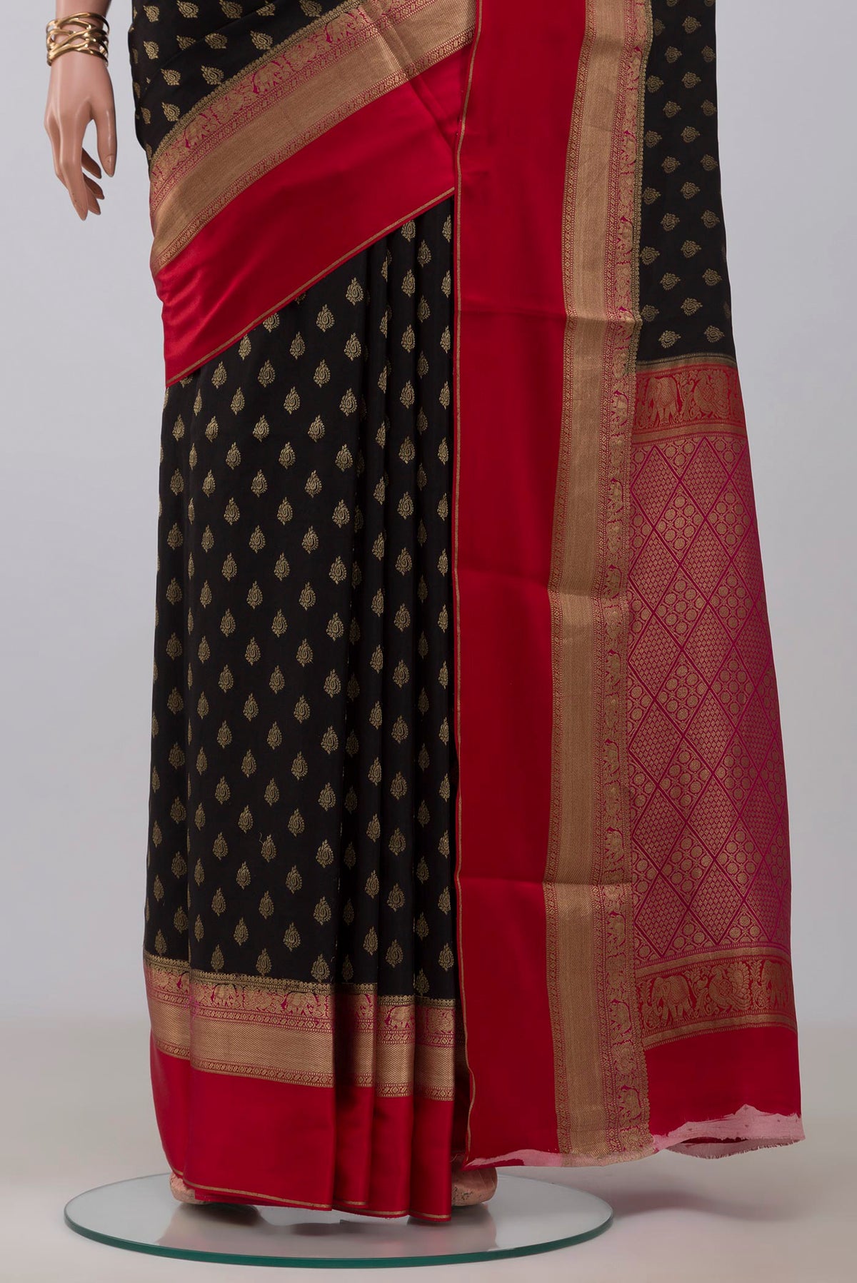 Pleats and pallu of Black Crepe Saree with Zari Butta on the body and Zari Border. 