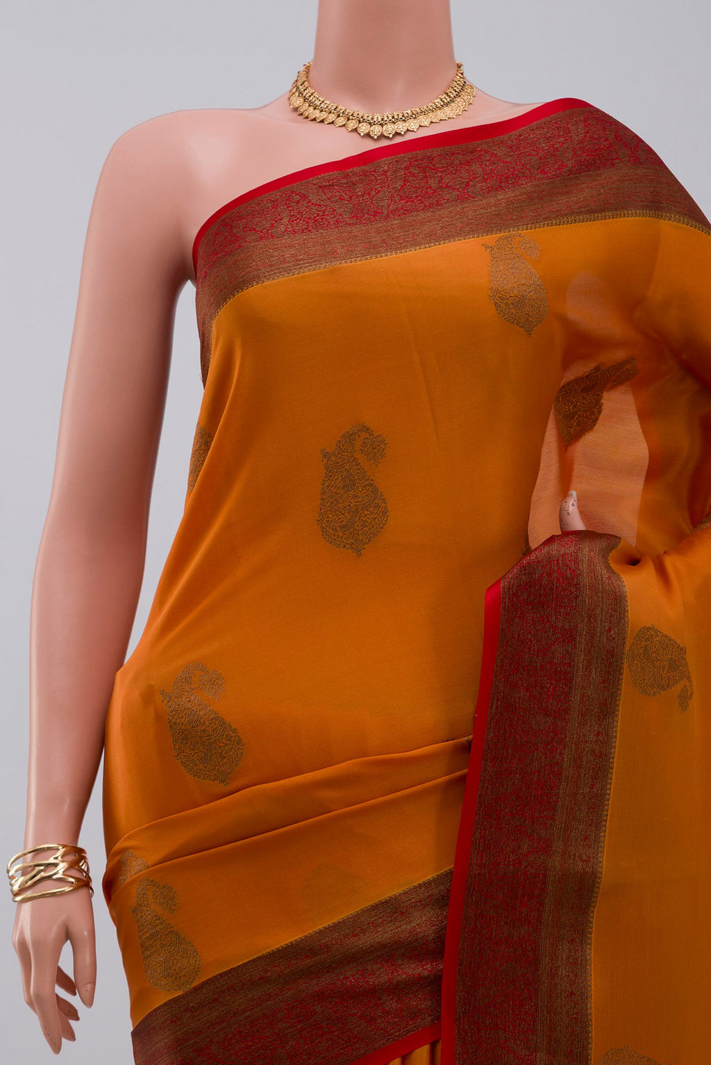 Border image of Orange Crepe Saree with Zari Butta on the body and Zari Border. 