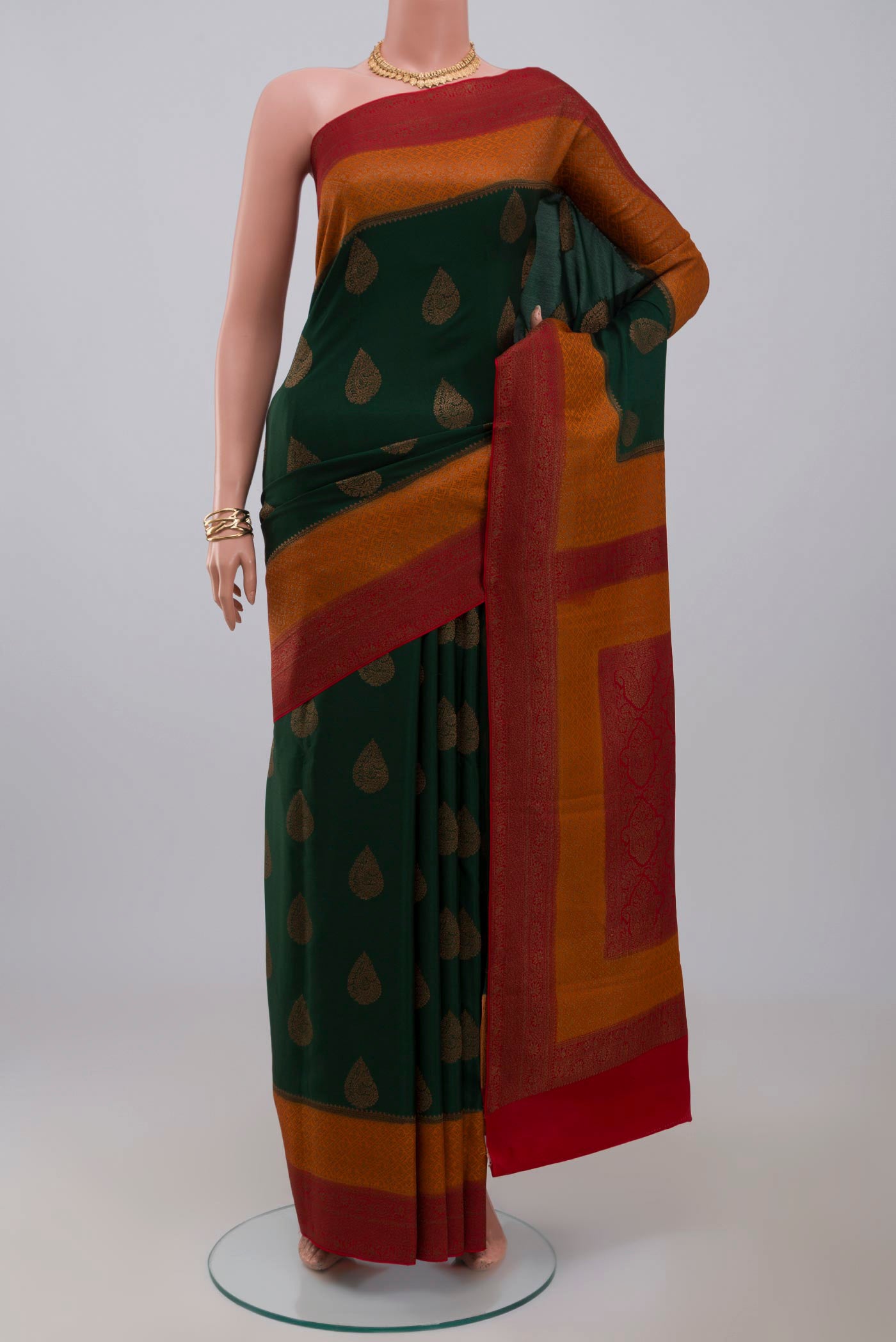 Green Crepe Saree with Zari Butta on the body and Zari Border.  displayed on a mannequin