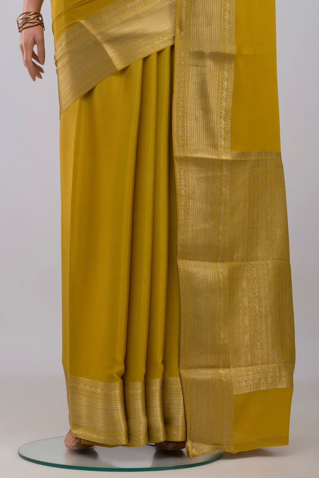 Pleats and pallu of Yellow Mysore Crepe Saree with Plain Body and Zari Border. 