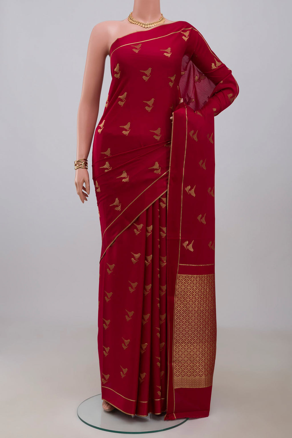 Red Crepe Saree with Zari Butta on the body and Thin Zari Line.  displayed on a mannequin