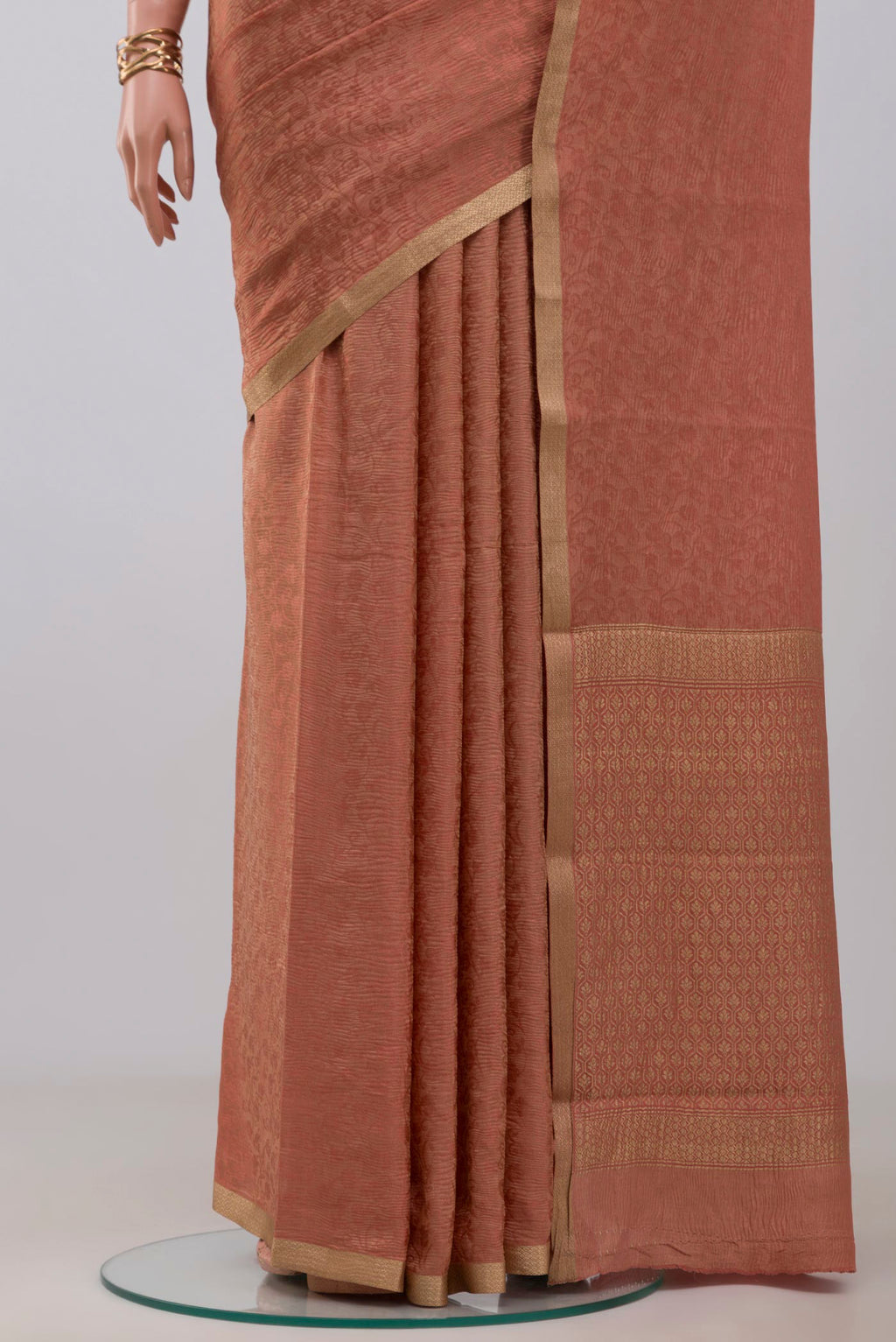 Pleats and pallu of Peach Crepe Saree with Fancy on the body and Zari Border. 