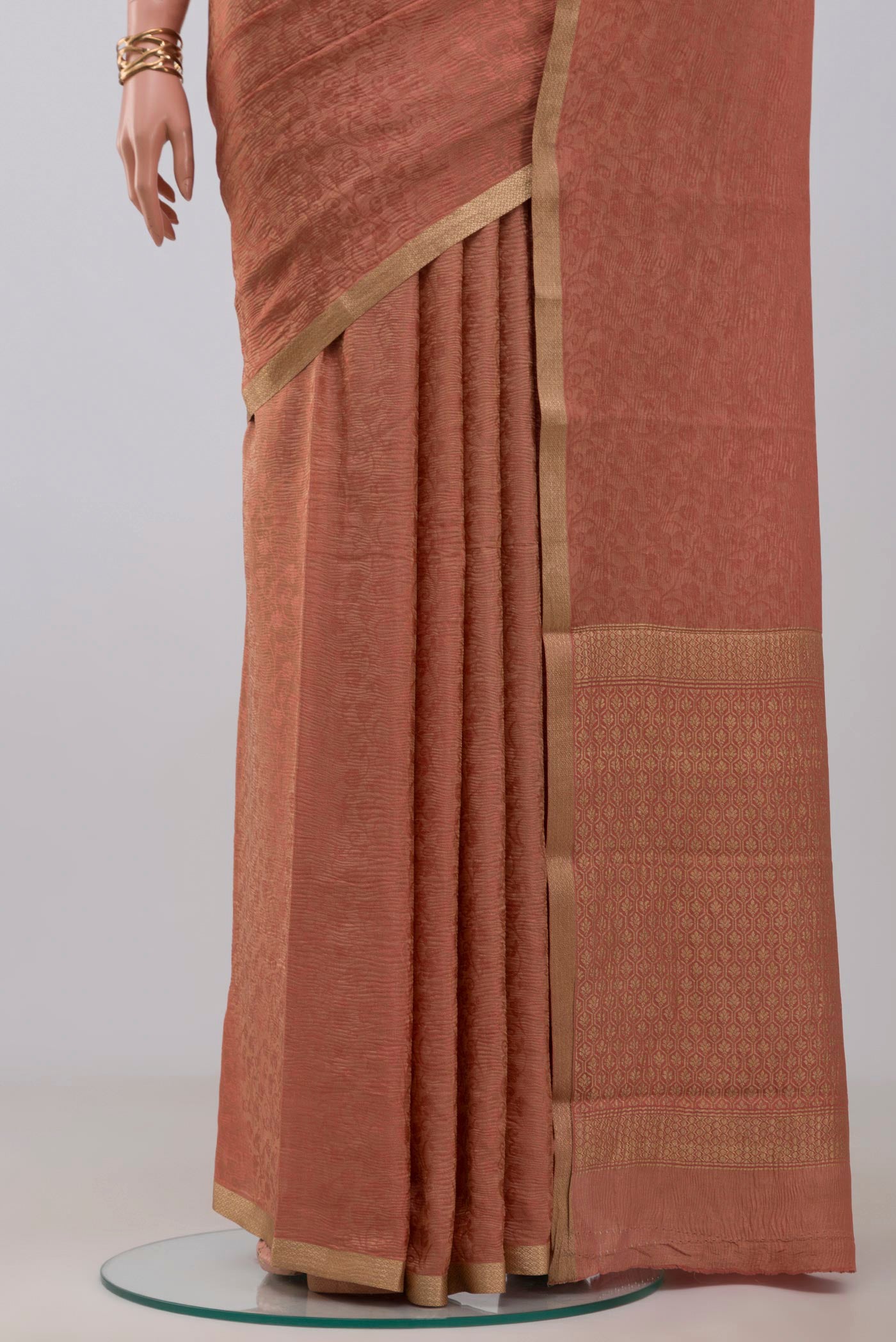 Pleats and pallu of Peach Crepe Saree with Fancy on the body and Zari Border. 