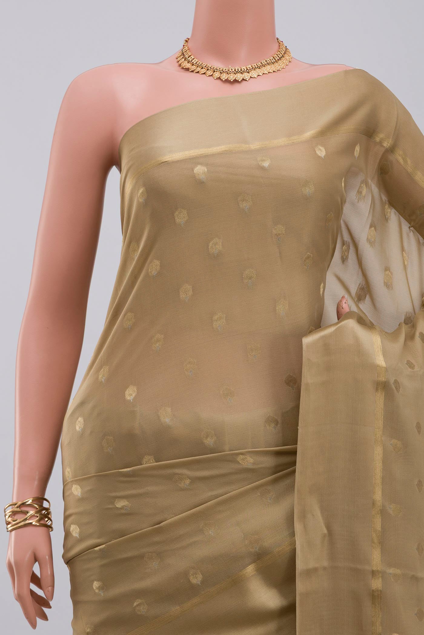 Border image of Beige Crepe Saree with Zari Butta on the body and Thin Zari Line. 