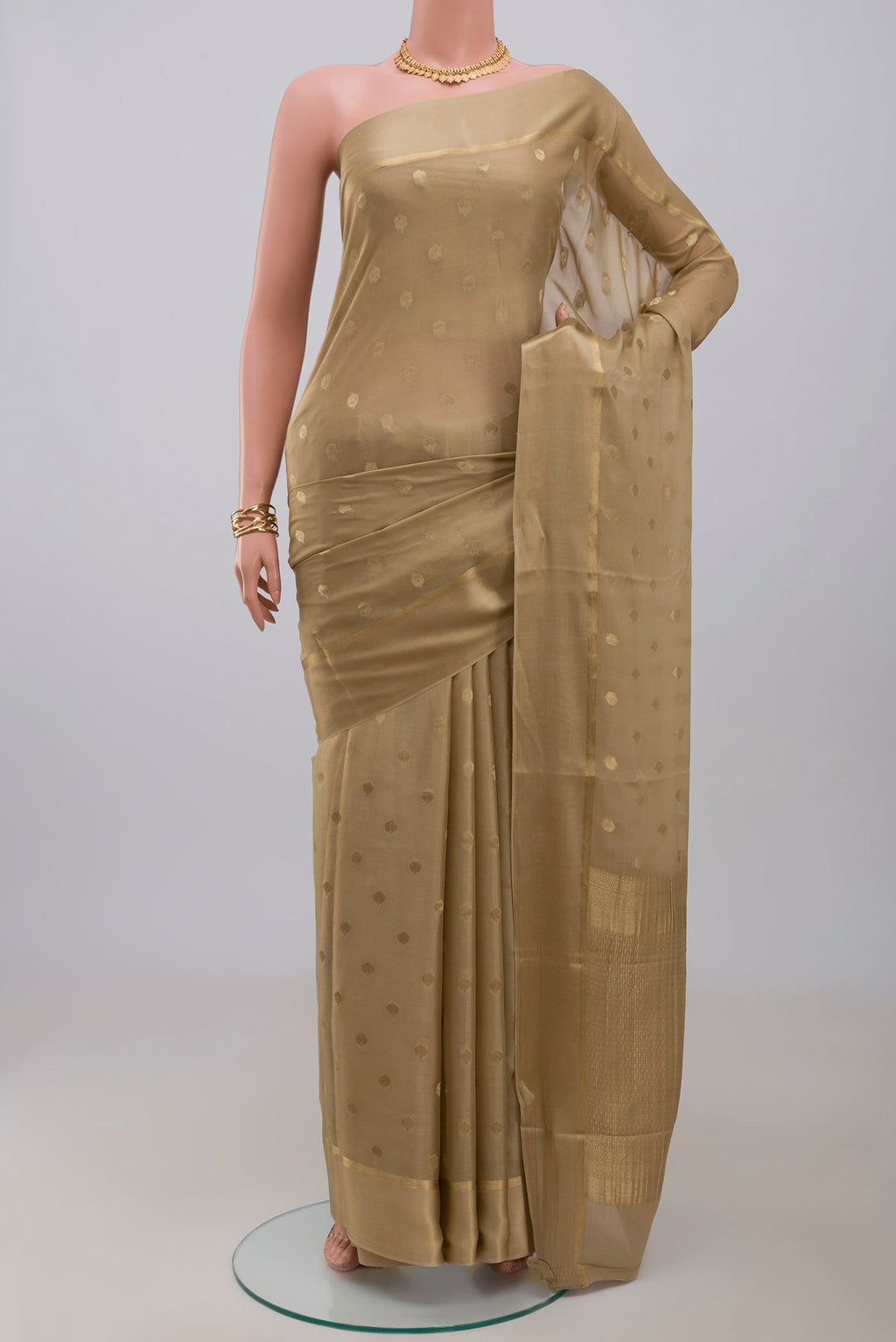 Beige Crepe Saree with Zari Butta on the body and Thin Zari Line.  displayed on a mannequin
