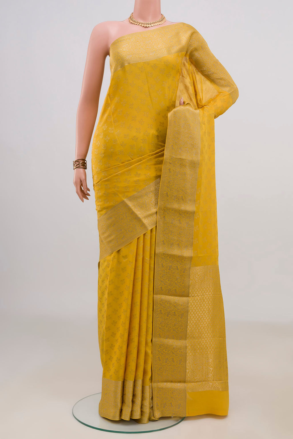 Yellow Mysore Crepe Saree with Zari Butta on the body and Zari Border.  displayed on a mannequin