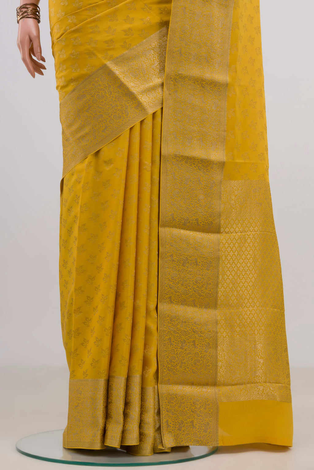 Pleats and pallu of Yellow Mysore Crepe Saree with Zari Butta on the body and Zari Border. 