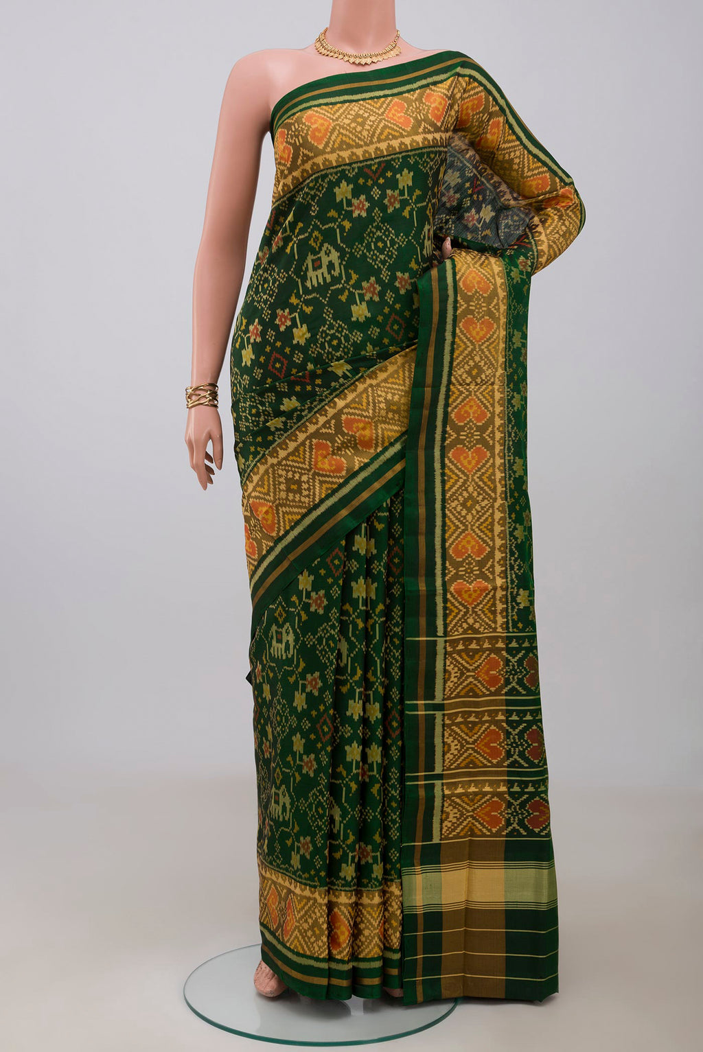 Bottle Green Rajkot Patola Silk Saree with Ikat design on the body and Ikat Border.  displayed on a mannequin