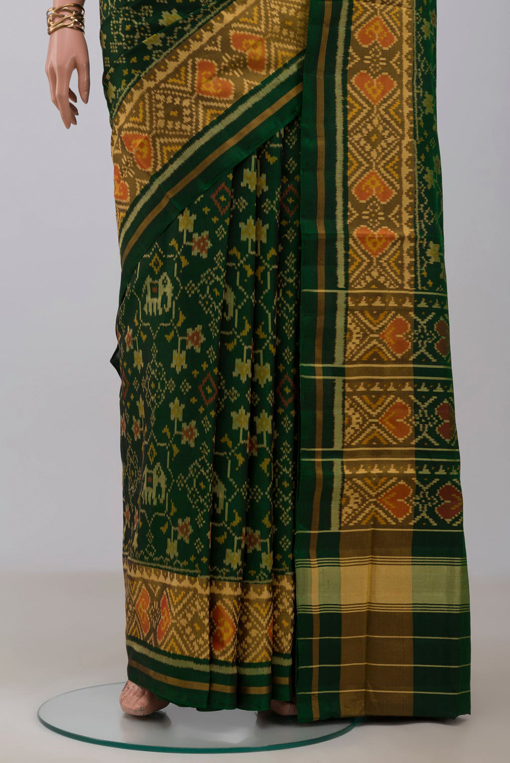 Pleats and pallu of Bottle Green Rajkot Patola Silk Saree with Ikat design on the body and Ikat Border. 