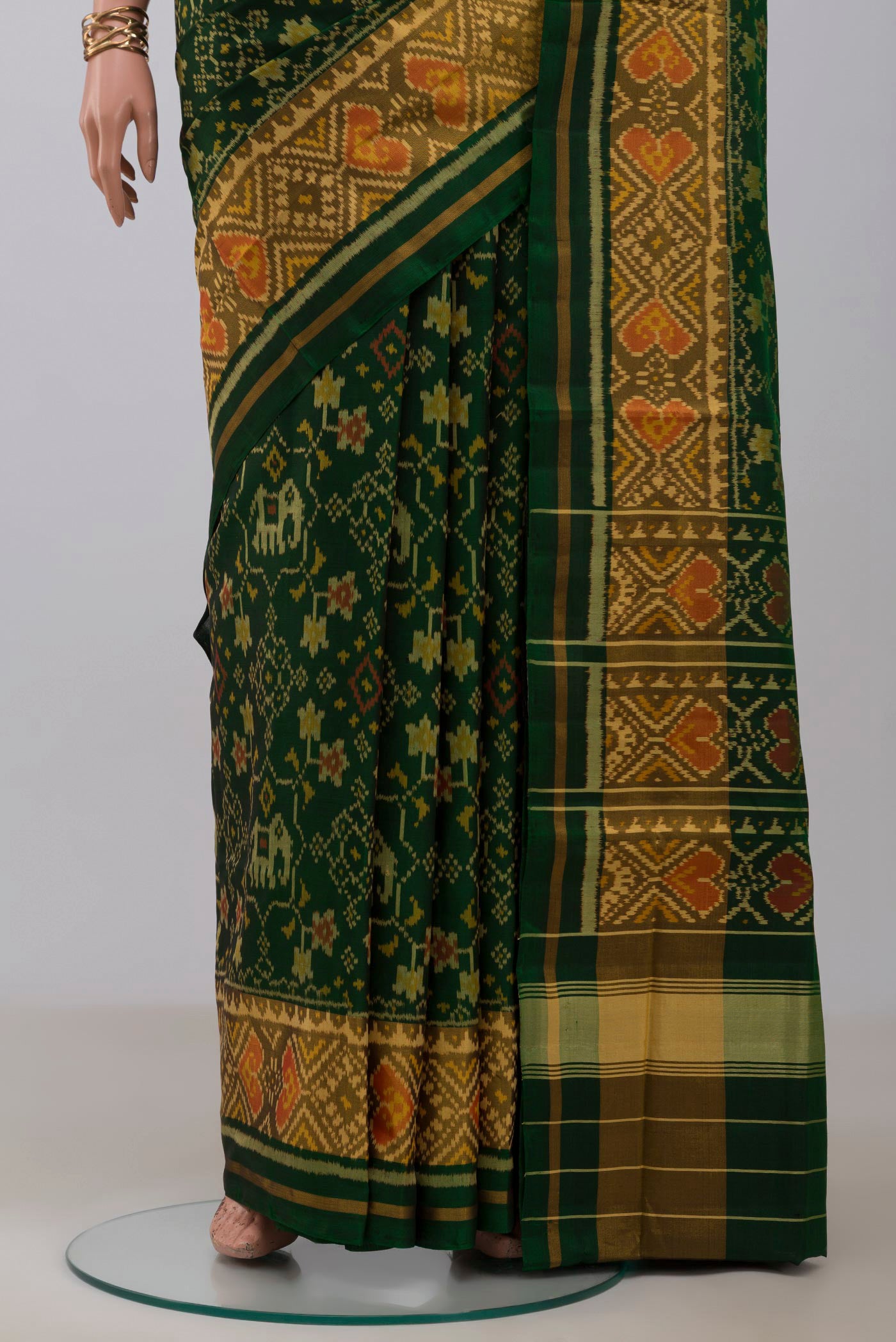 Pleats and pallu of Bottle Green Rajkot Patola Silk Saree with Ikat design on the body and Ikat Border. 