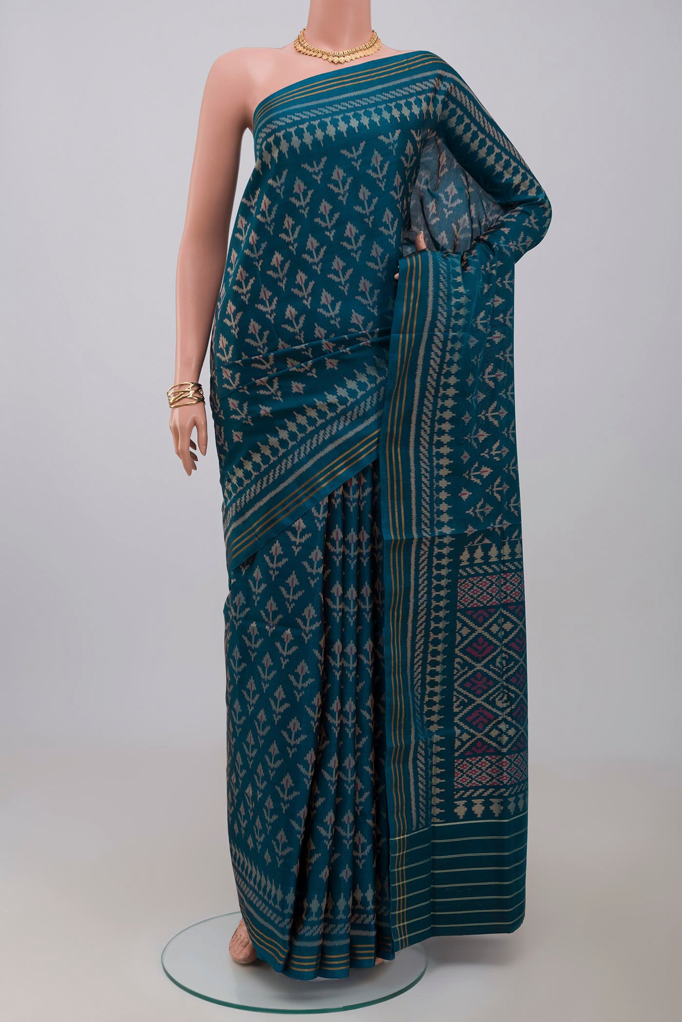 Blue Rajkot Patola Silk Saree with Ikat design on the body and Thin Zari Line.  displayed on a mannequin