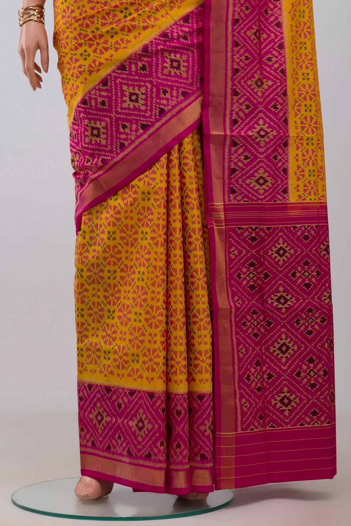 Pleats and pallu of Yellow Rajkot Patola Silk Saree with Ikat design on the body and Ikat Border. 