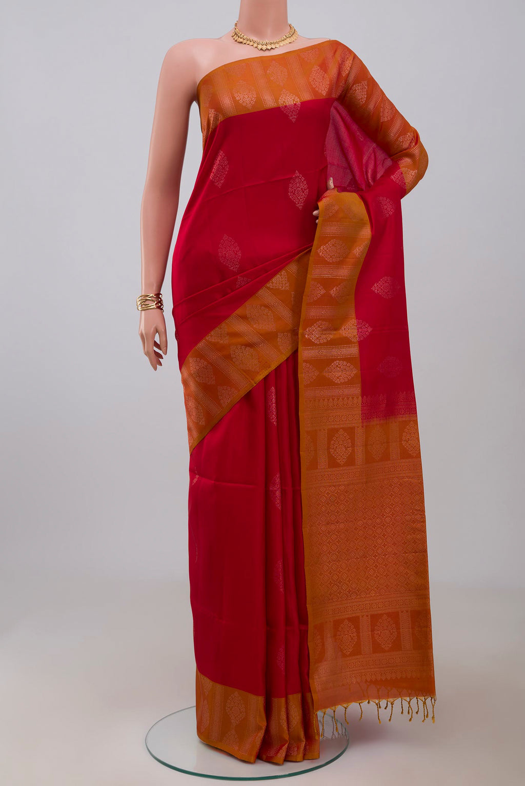 Red Soft Silk Saree with Zari Butta on the body and Fancy Border.  displayed on a mannequin