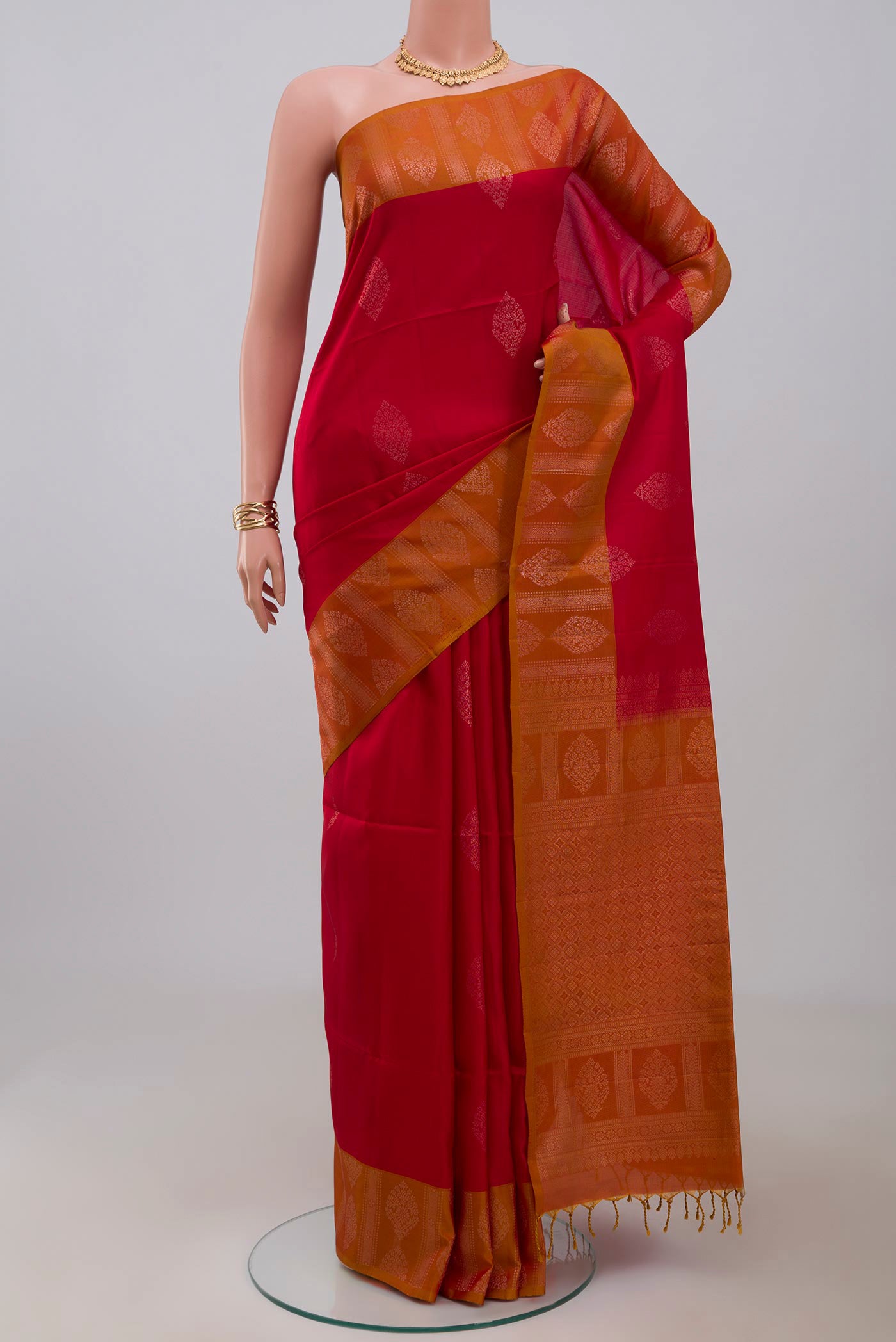 Red Soft Silk Saree with Zari Butta on the body and Fancy Border.  displayed on a mannequin