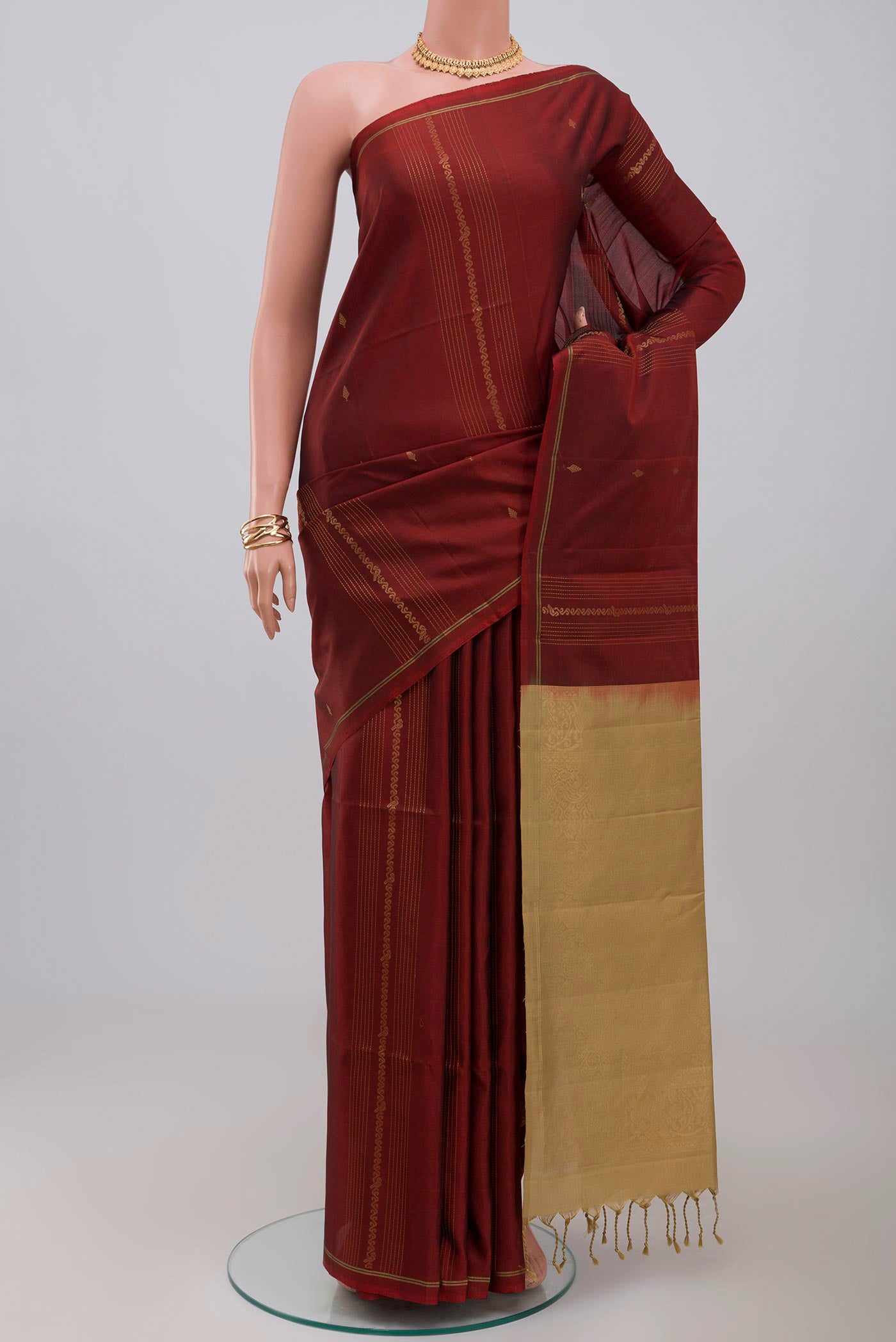 Maroon Soft Silk Saree with Fancy on the body and Thin Zari Line.  displayed on a mannequin