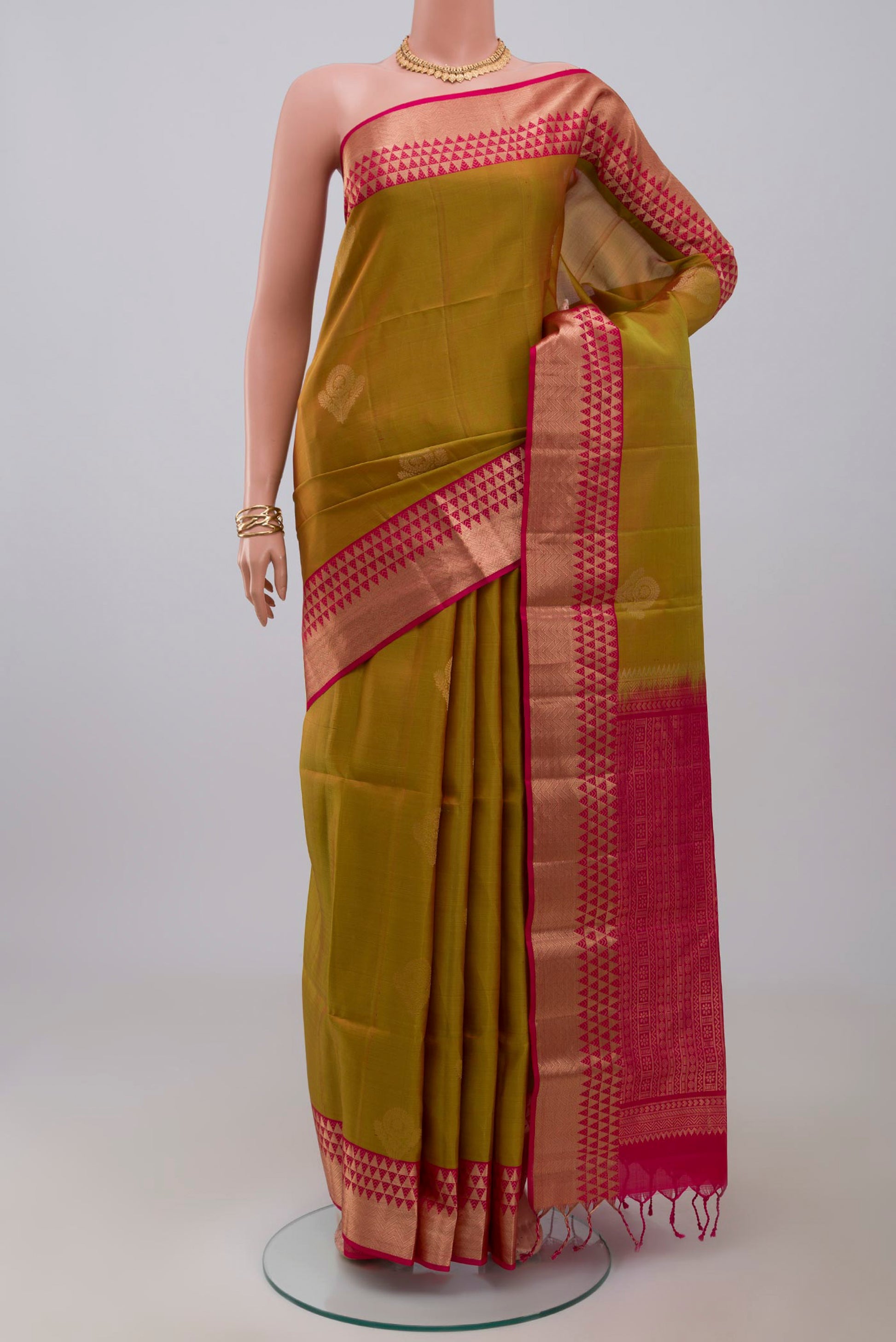 Green Soft Silk Saree with Zari Butta on the body and Zari Border.  displayed on a mannequin