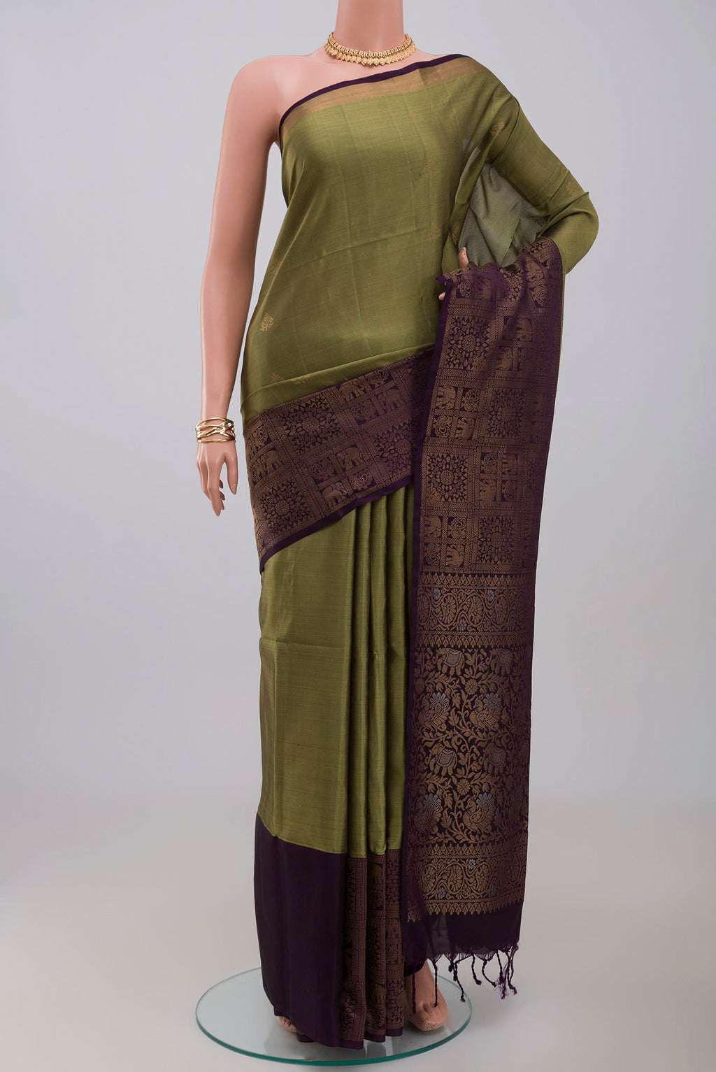 Mehandi Green Soft Silk Saree with Zari Butta on the body and Fancy Border.  displayed on a mannequin