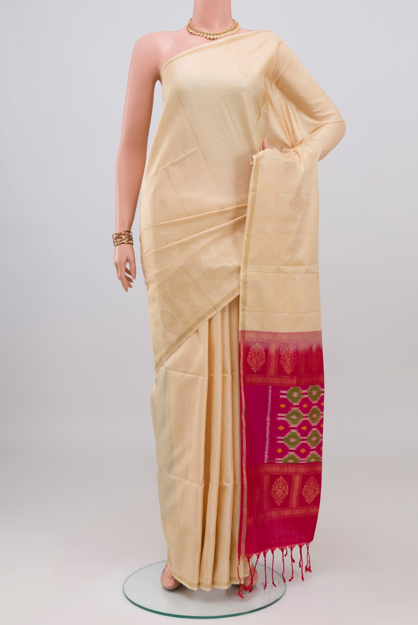 Cream Soft Silk Saree with Zari Butta on the body and Fancy Border.  displayed on a mannequin