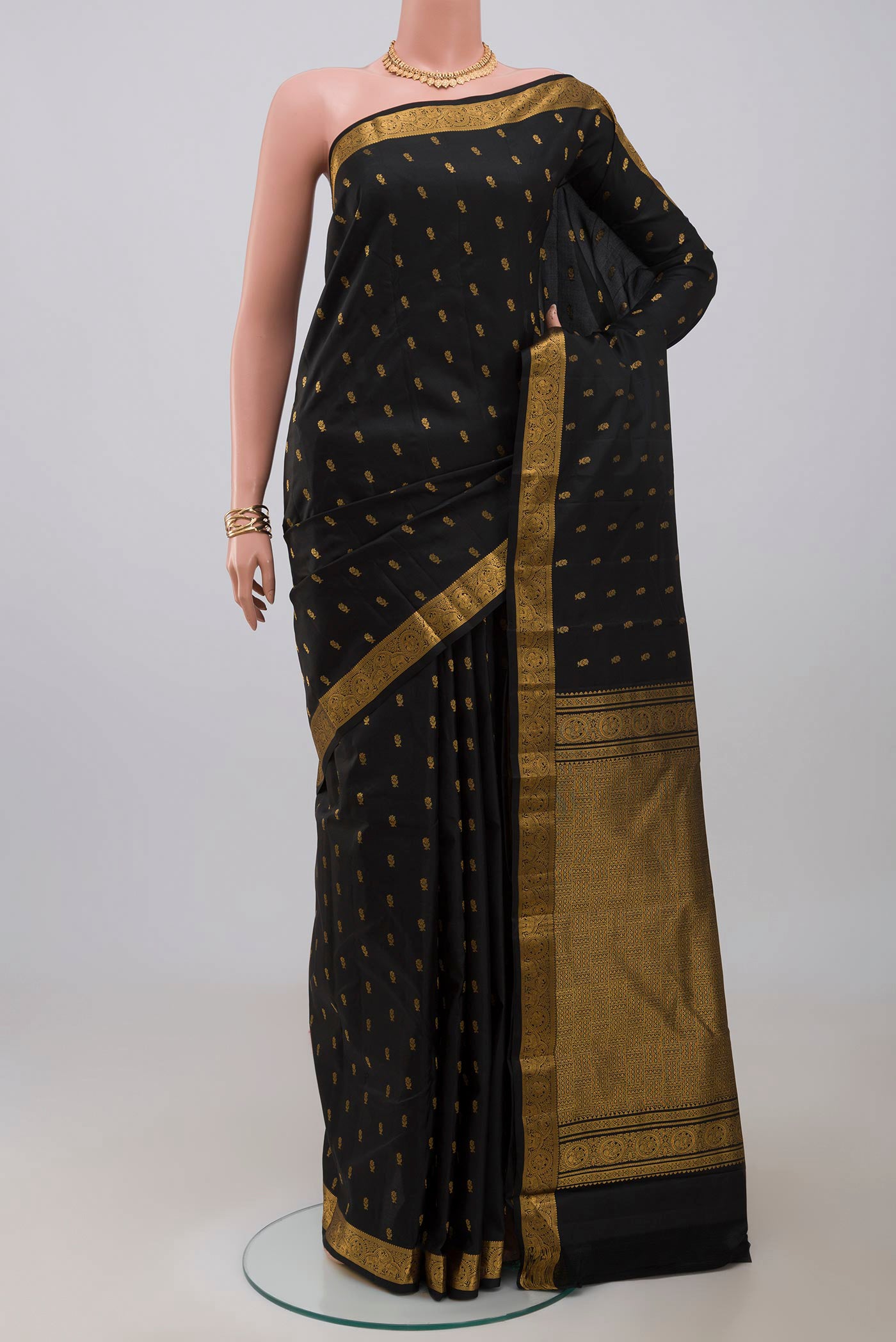 Black Kanchipuram Saree with Zari Butta on the body and Zari Border.  displayed on a mannequin