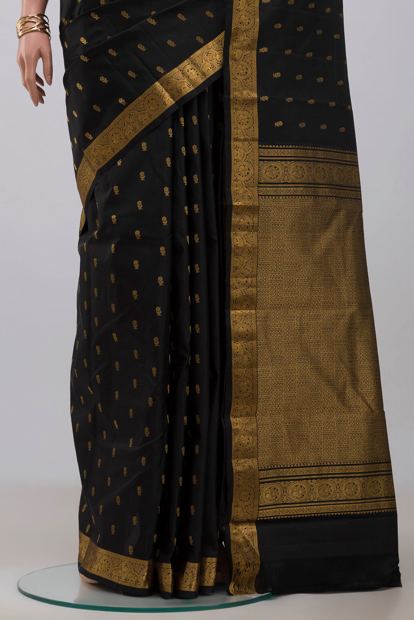 Pleats and pallu of Black Kanchipuram Saree with Zari Butta on the body and Zari Border. 